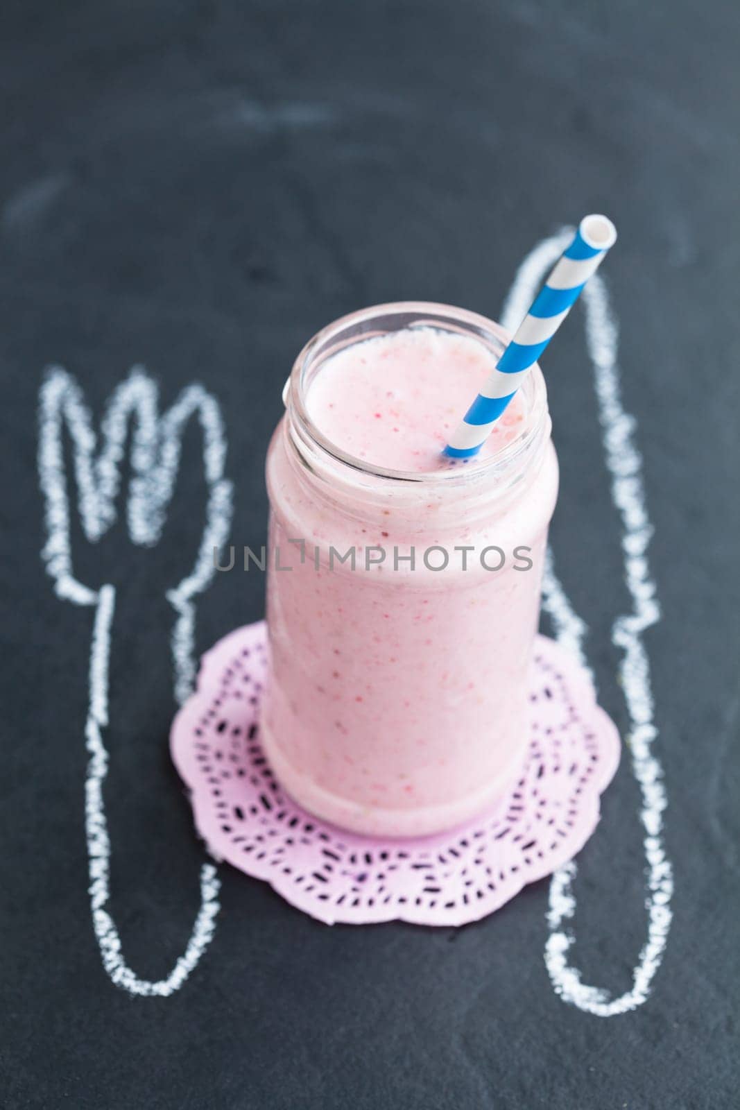 Strawberry smoothie with striped straw with knife and fork chalk drawing