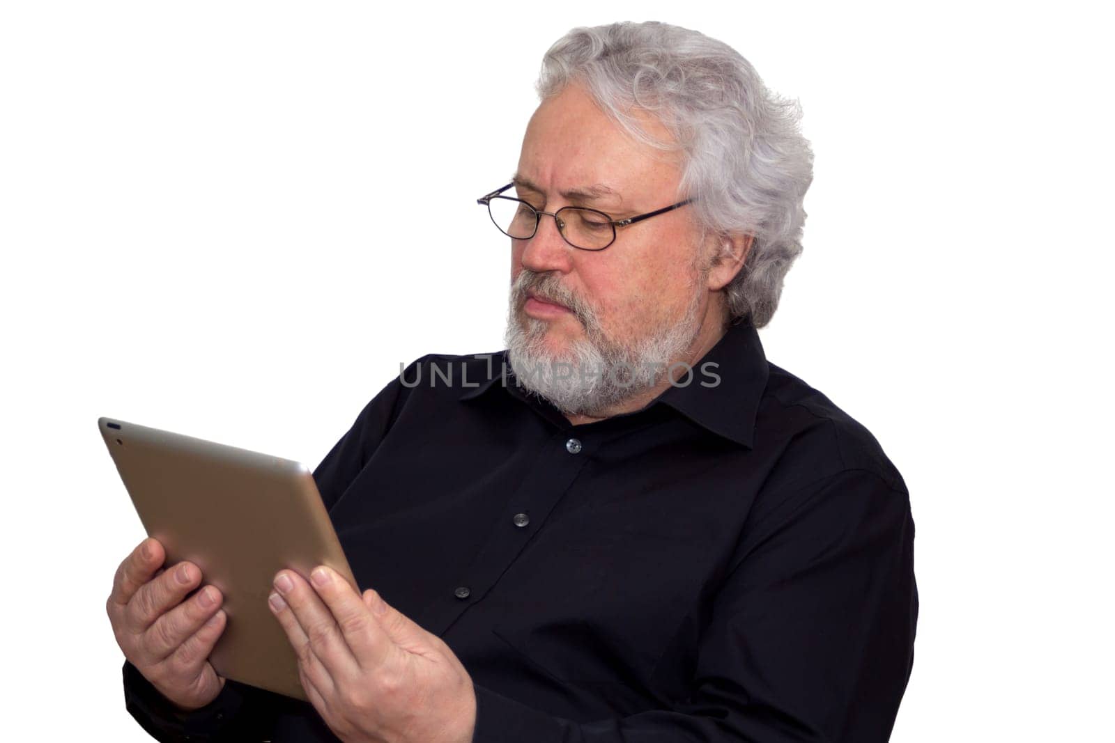A senior with grey hair is holding a tablet and looking at it