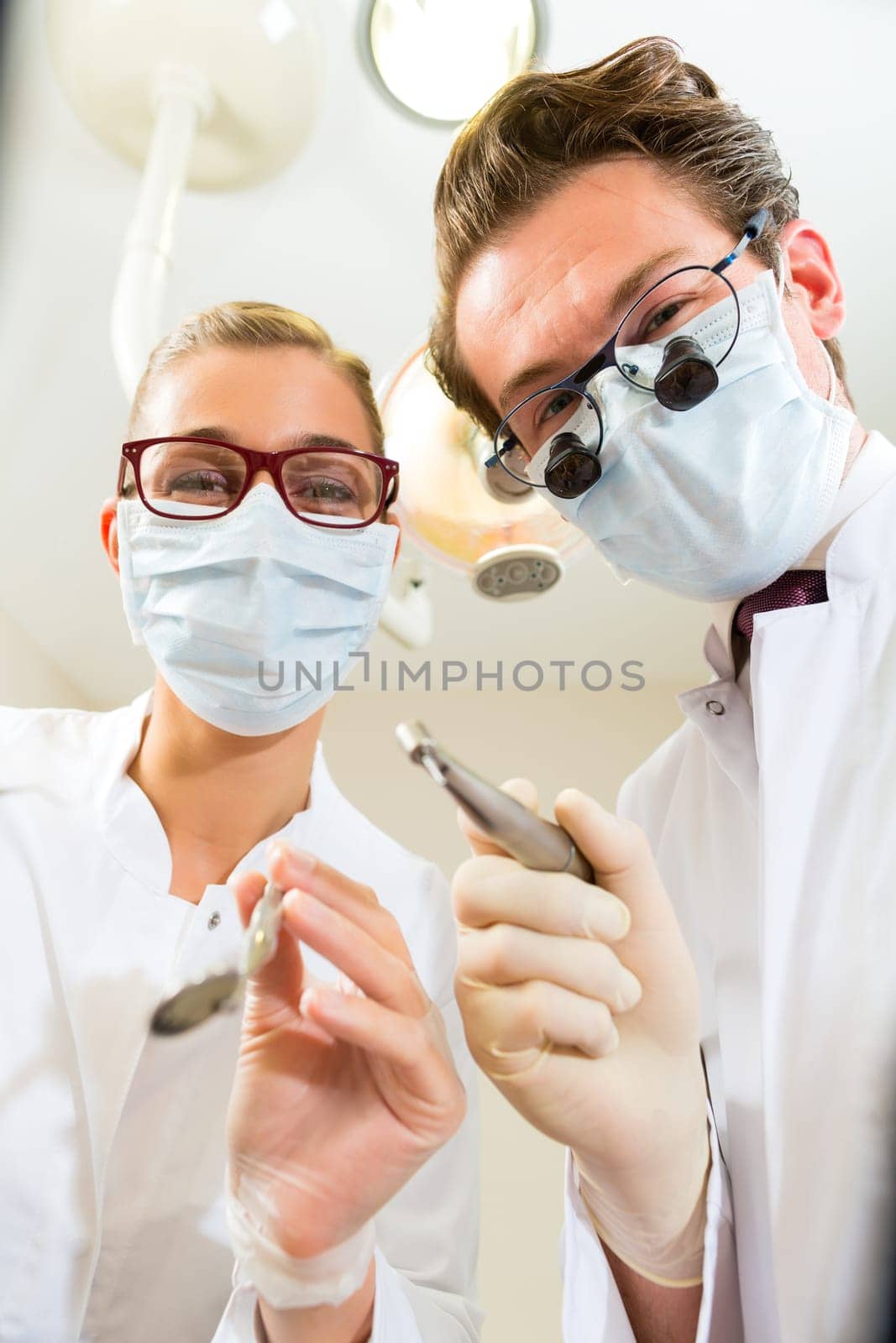 Dentist with dental assistant during a treatment from the patient's point of view