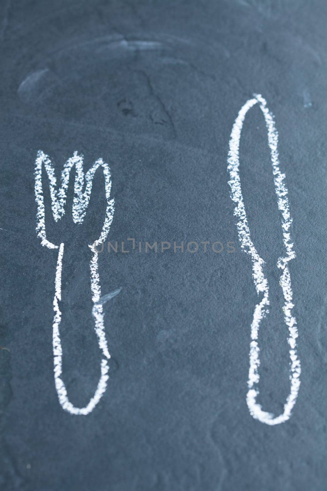 Simple drawing of knife and fork on dark background