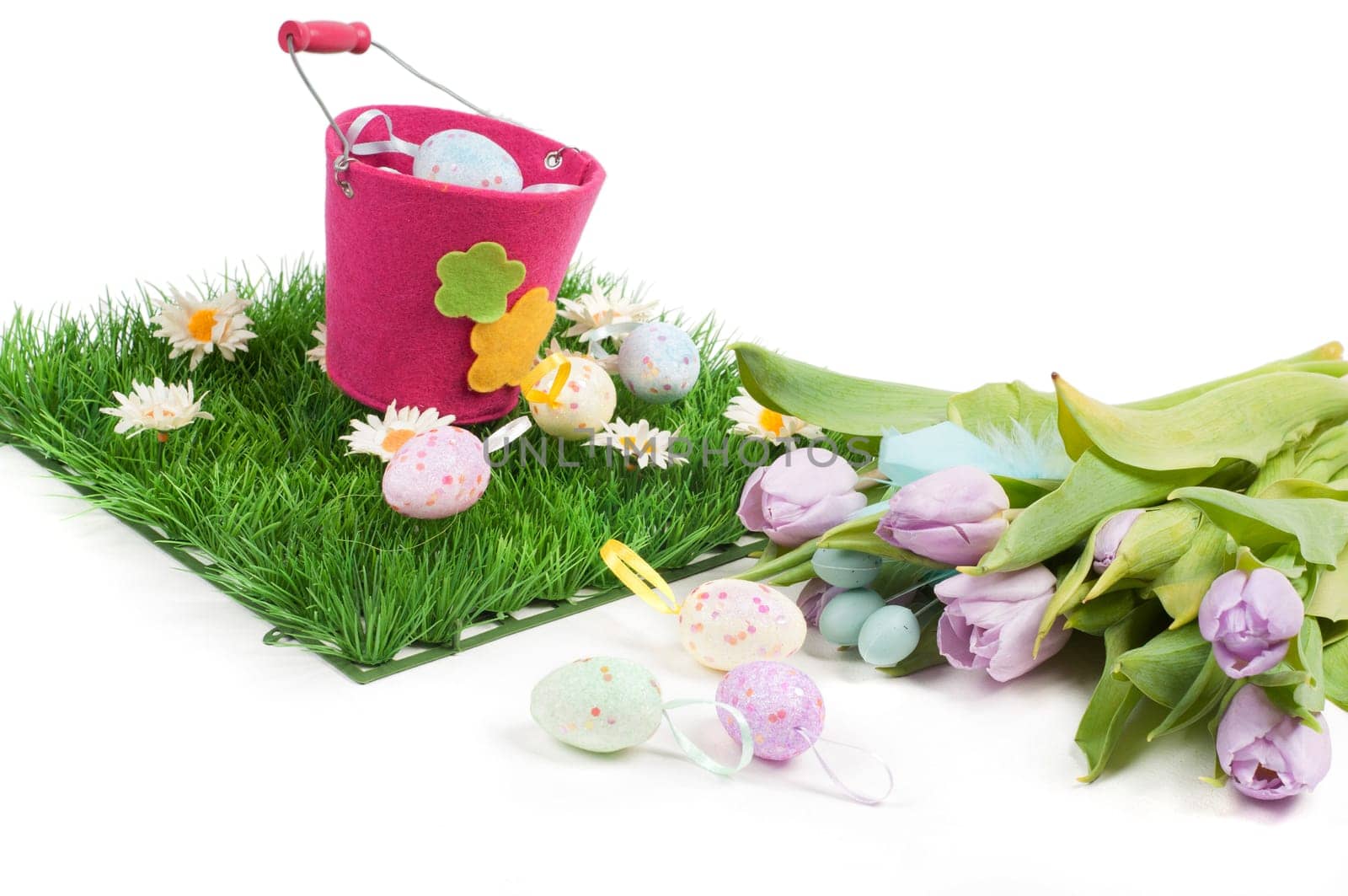 Easter composition with tulips, eggs, green grass and pail