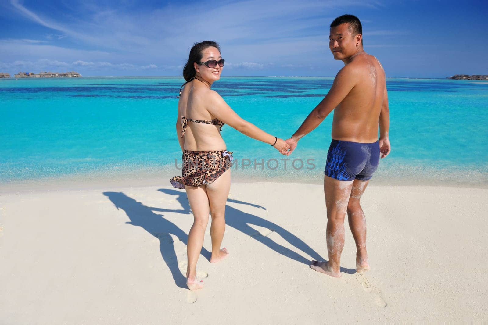 happy young asian couple have fun and romantic time at  summer on beautiful white sand beach