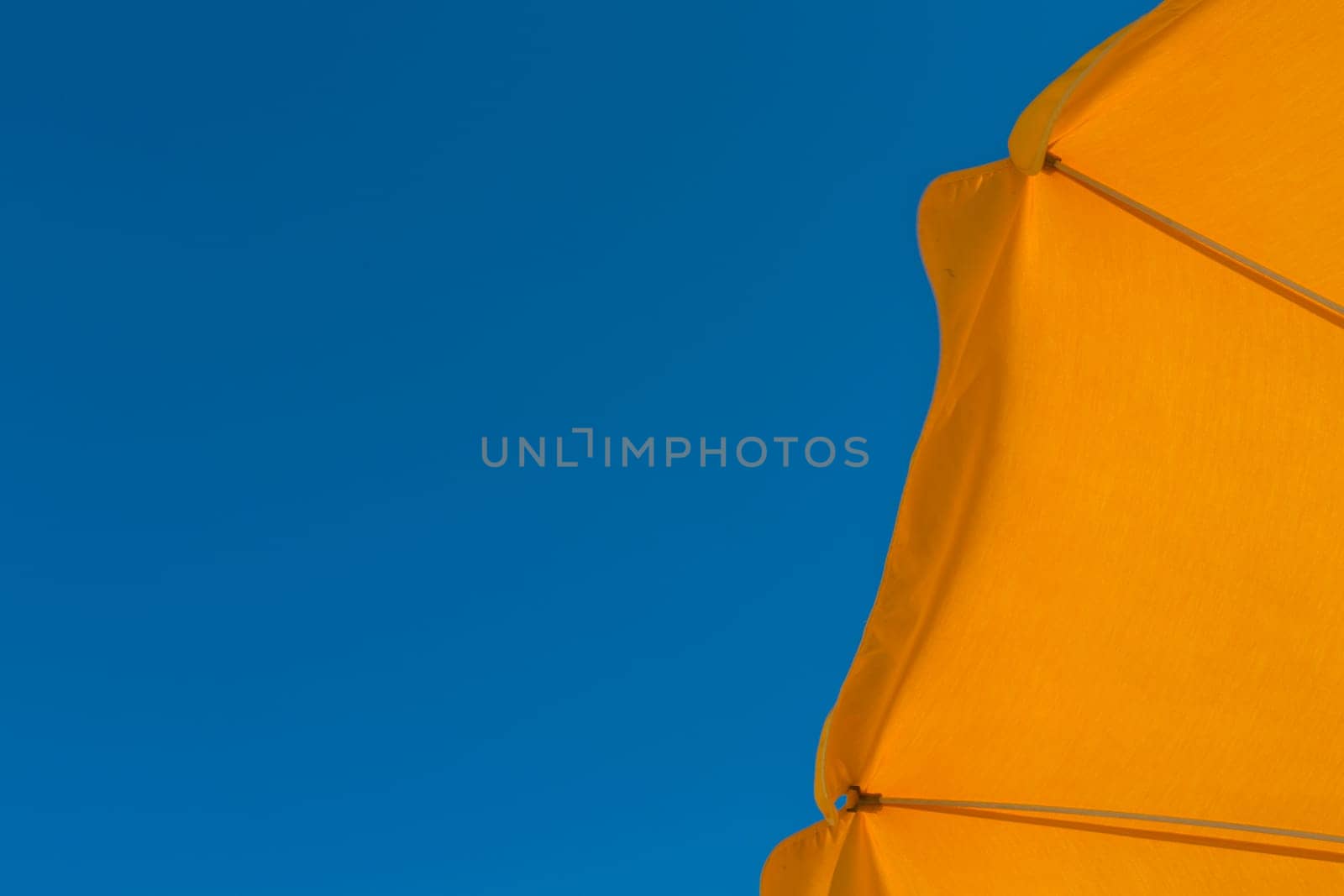 Yellow parasol against blue sky