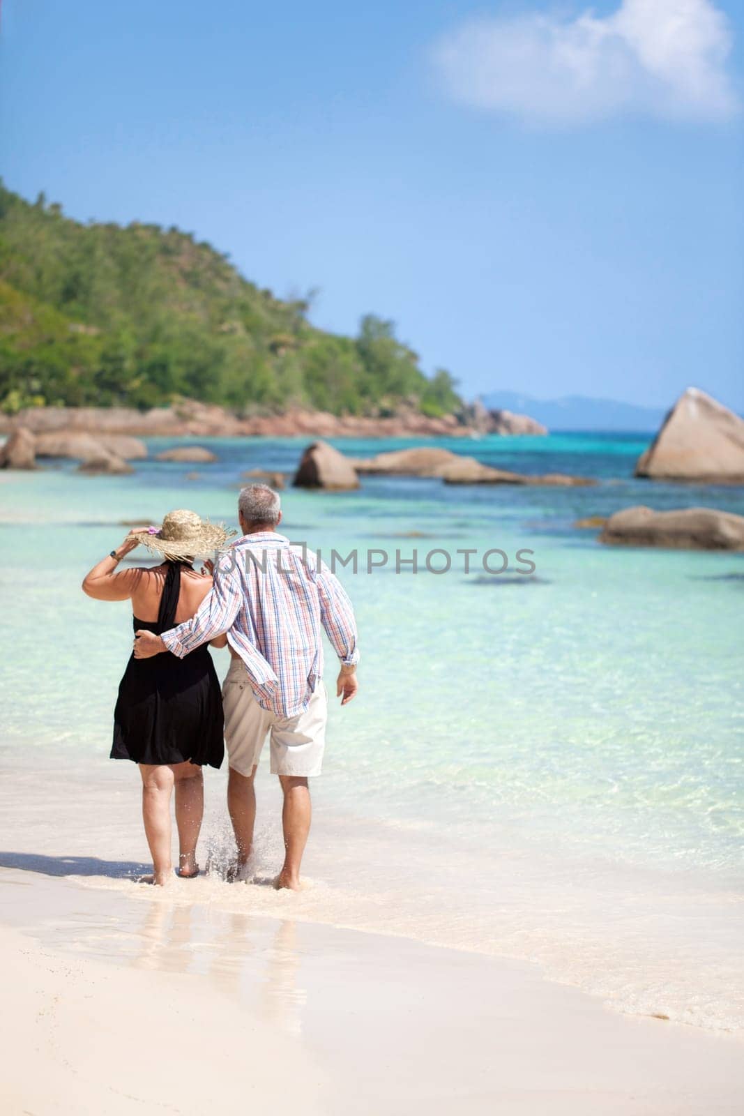 Modern couple walking on the beach - Seychelles