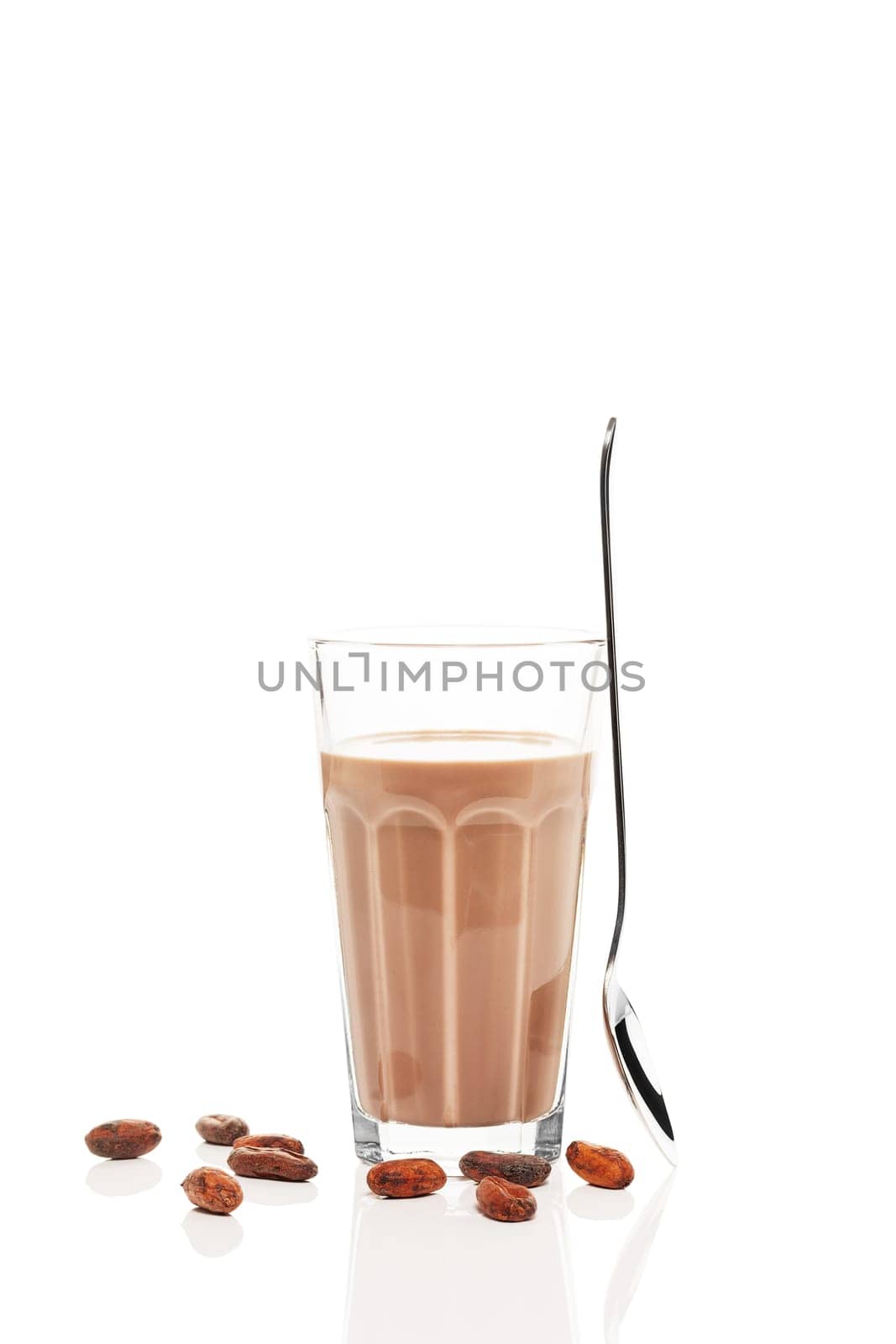 Chocolate milk with standing spoon and chocolate beans on white background