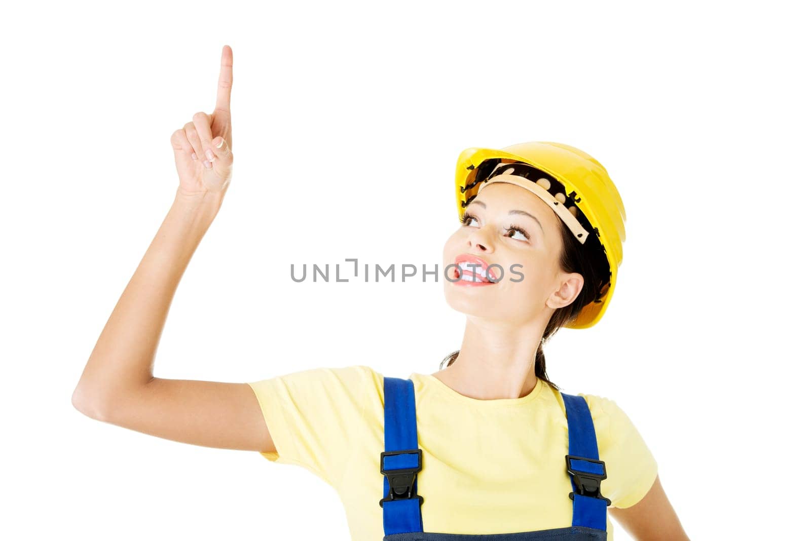 Female construction worker pointing on copy space, isolated on white