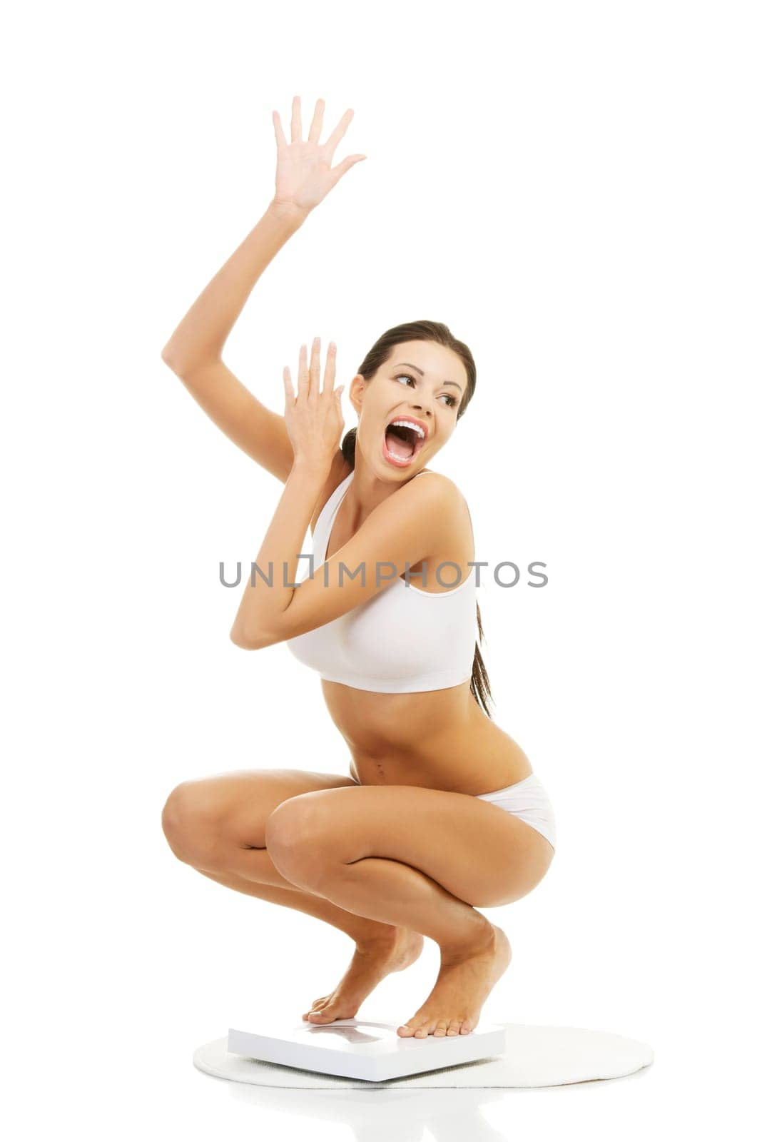 Happy woman on scales. Weight-loss concept.