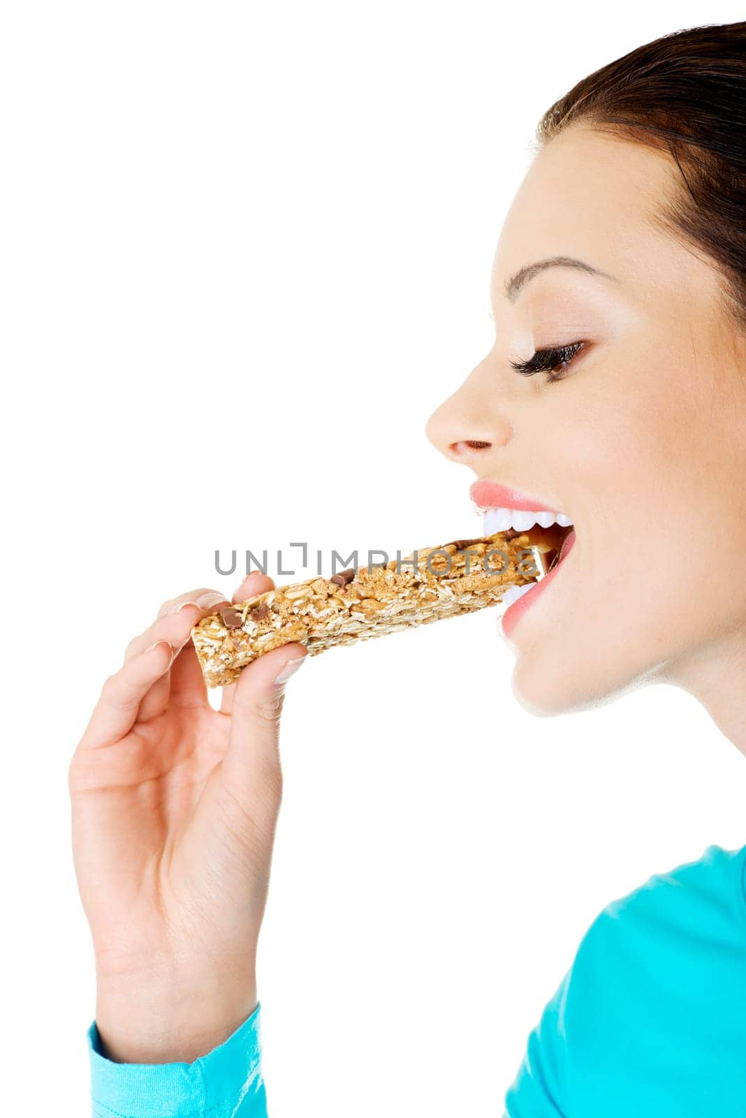 Young woman eating Cereal candy bar, isolated on white