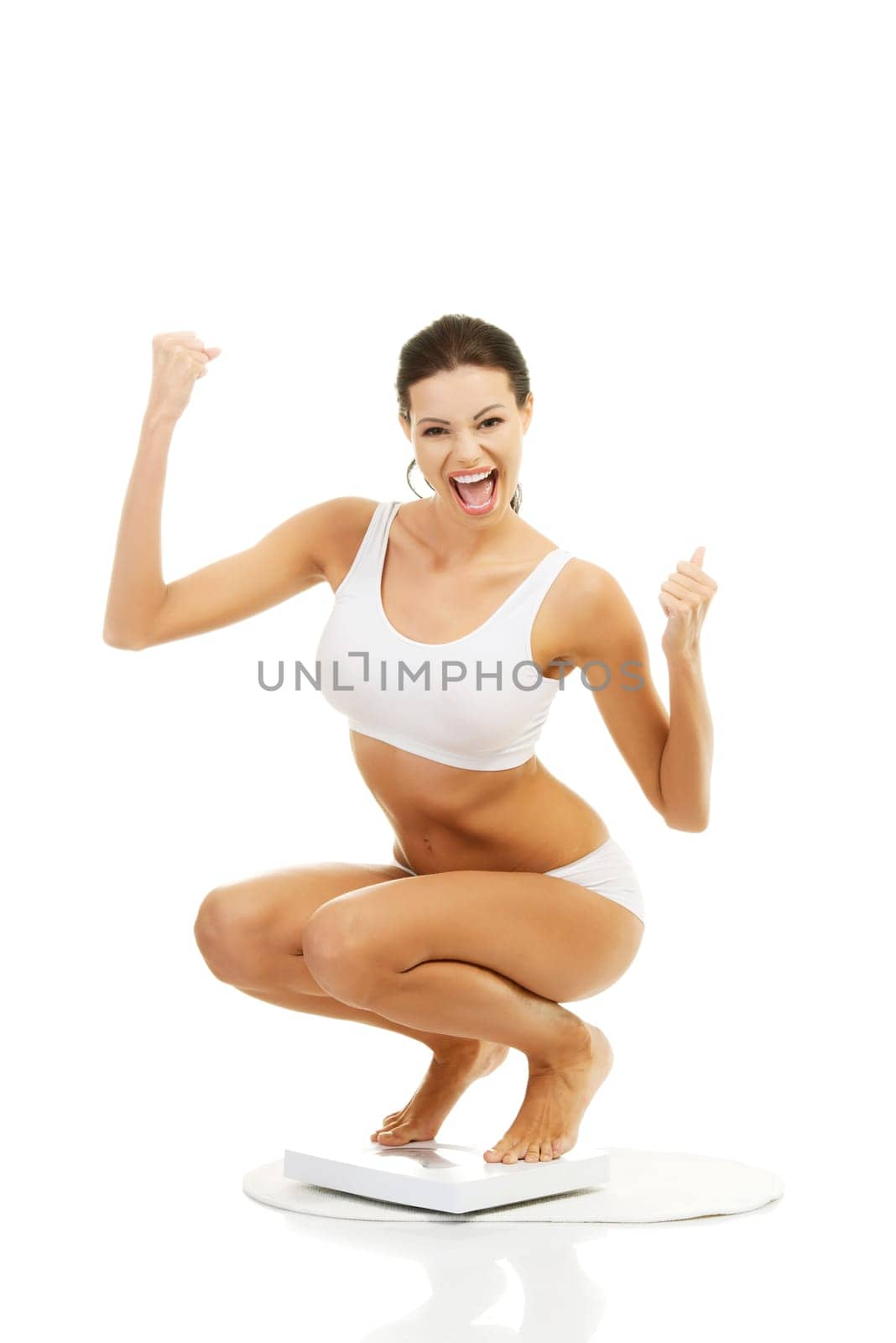Happy woman on scales. Weight-loss concept.