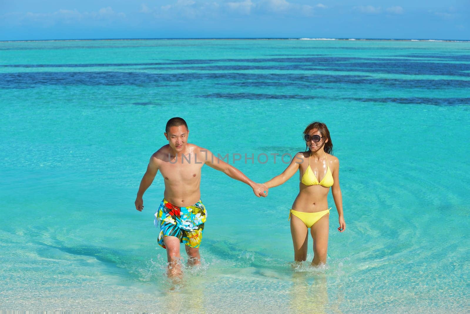 happy young asian couple have fun and romantic time at  summer on beautiful white sand beach