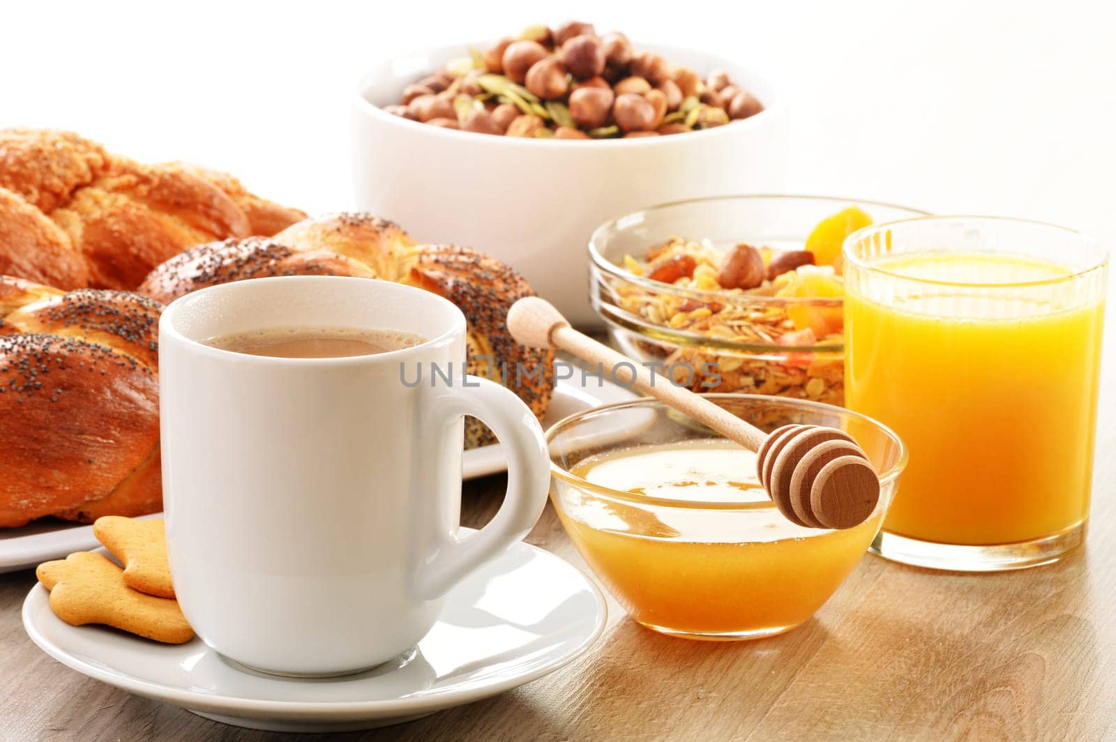 Breakfast including coffee, bread, honey, orange juice, muesli and fruits