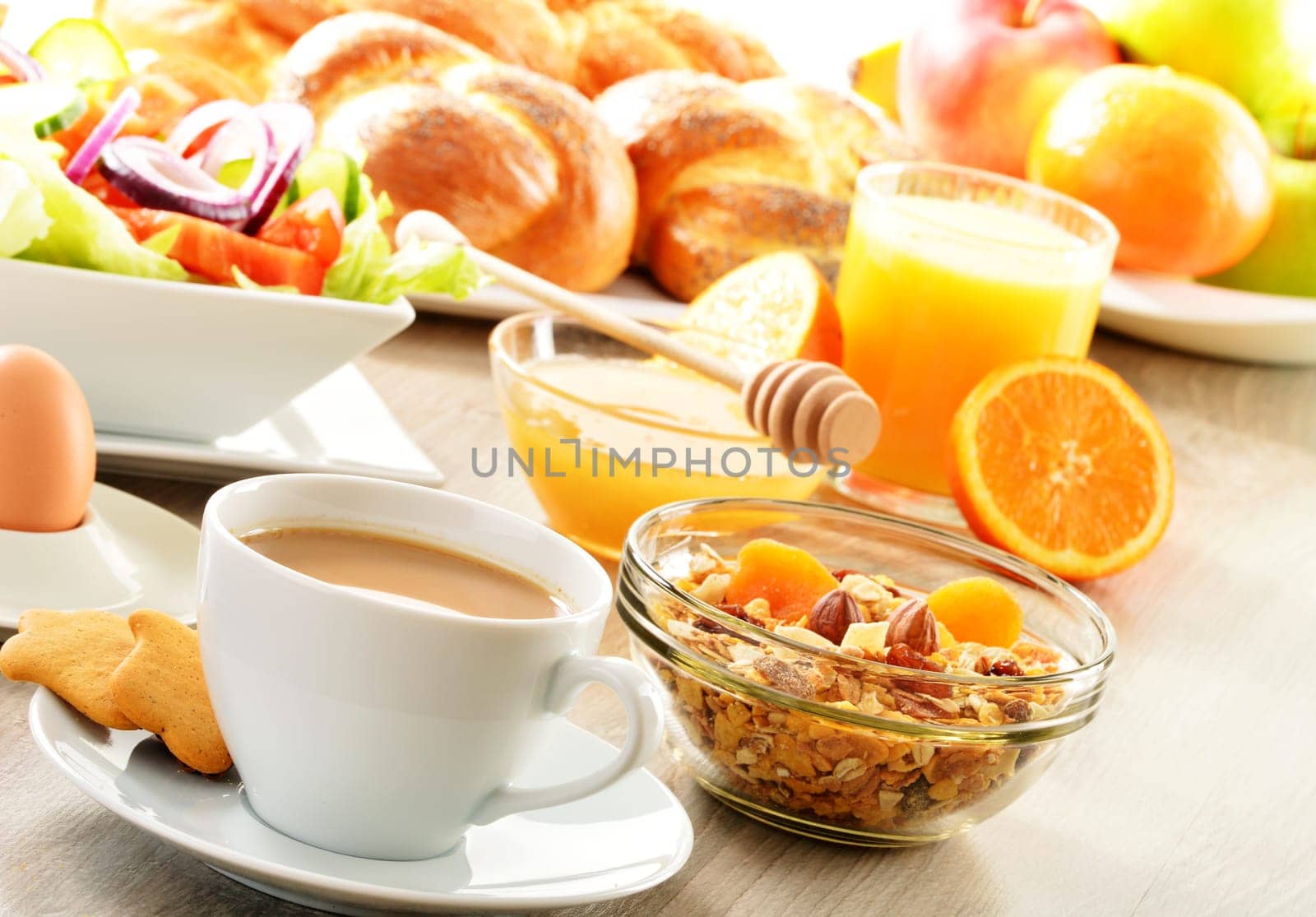 Breakfast including coffee, bread, honey, orange juice, muesli and fruits