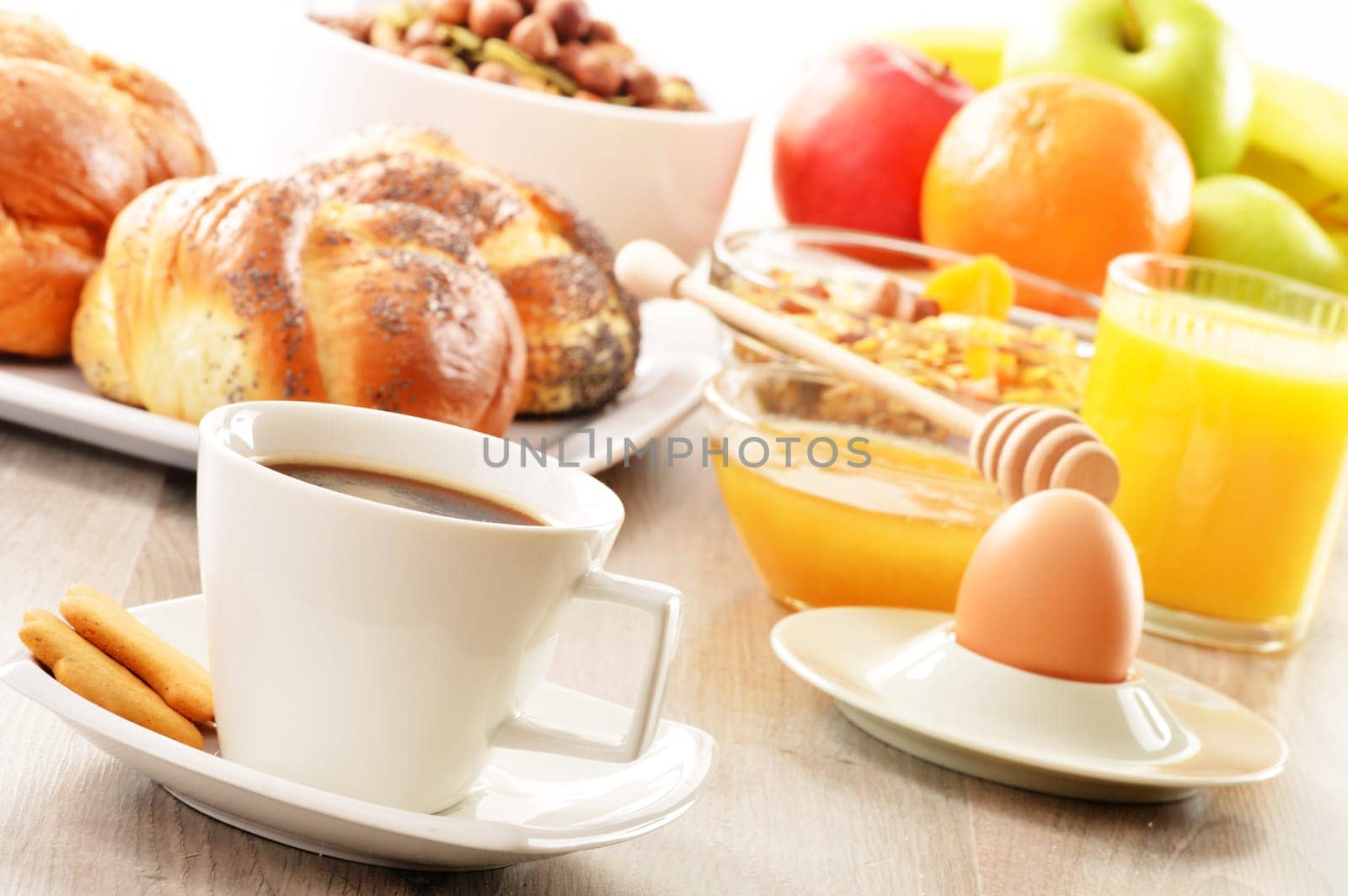 Breakfast including coffee, bread, honey, orange juice, muesli and fruits