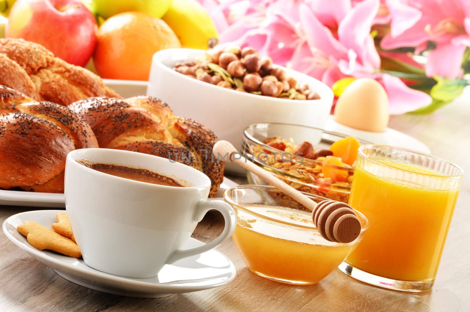 Breakfast including coffee, bread, honey, orange juice, muesli and fruits
