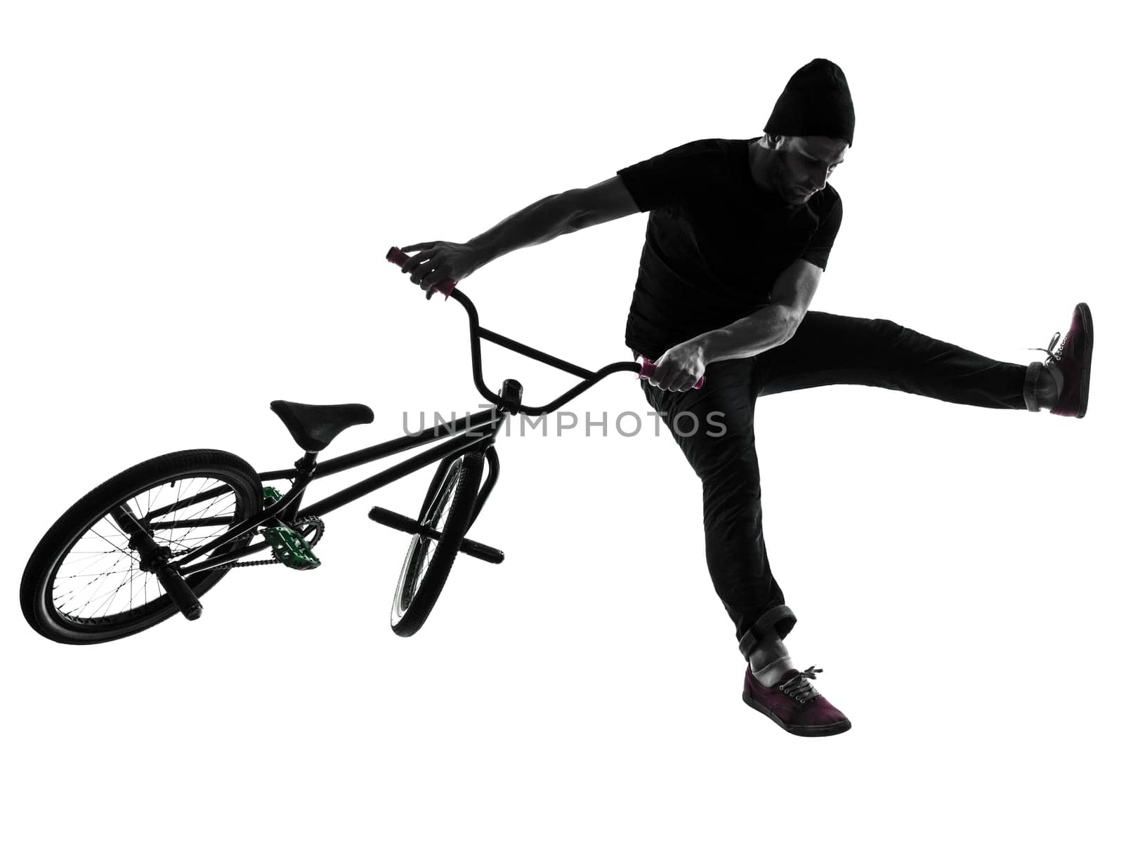 one caucasian man exercising bmx acrobatic figure in silhouette studio isolated on white background