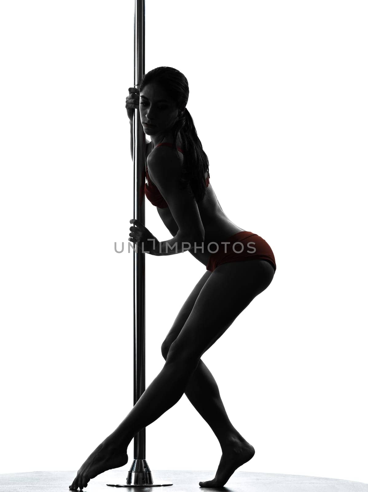 one caucasian woman pole dancer dancing in silhouette studio isolated on white background