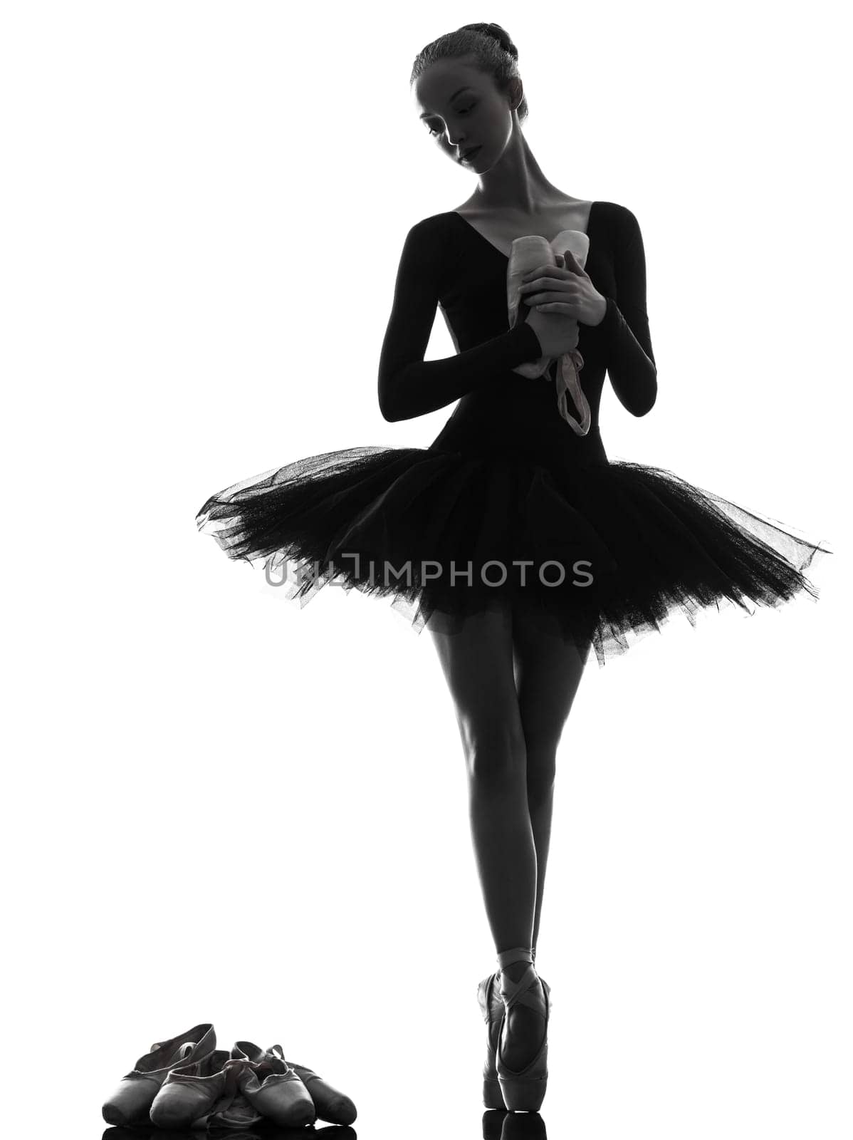 one caucasian young woman ballerina ballet dancer dancing with tutu in silhouette studio on white background