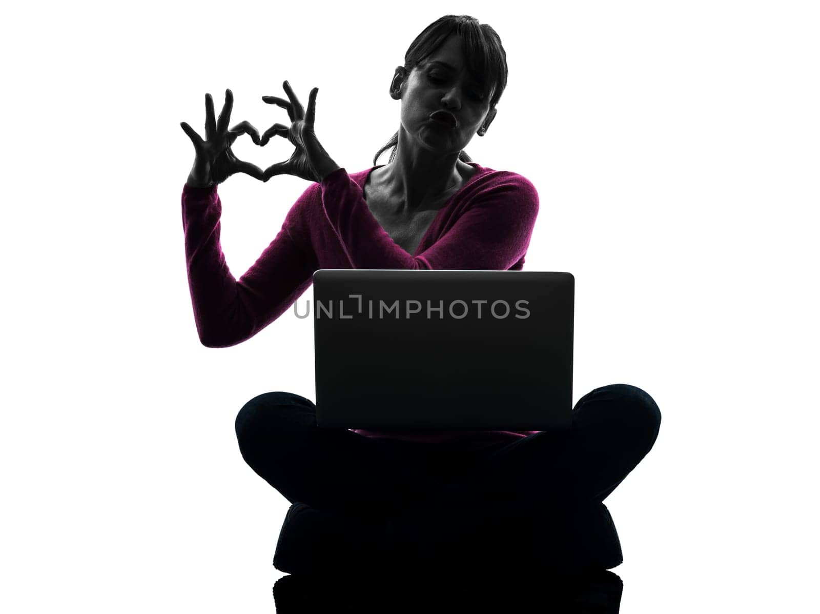 one caucasian woman heart gesture computing laptop computer  in silhouette studio isolated on white background