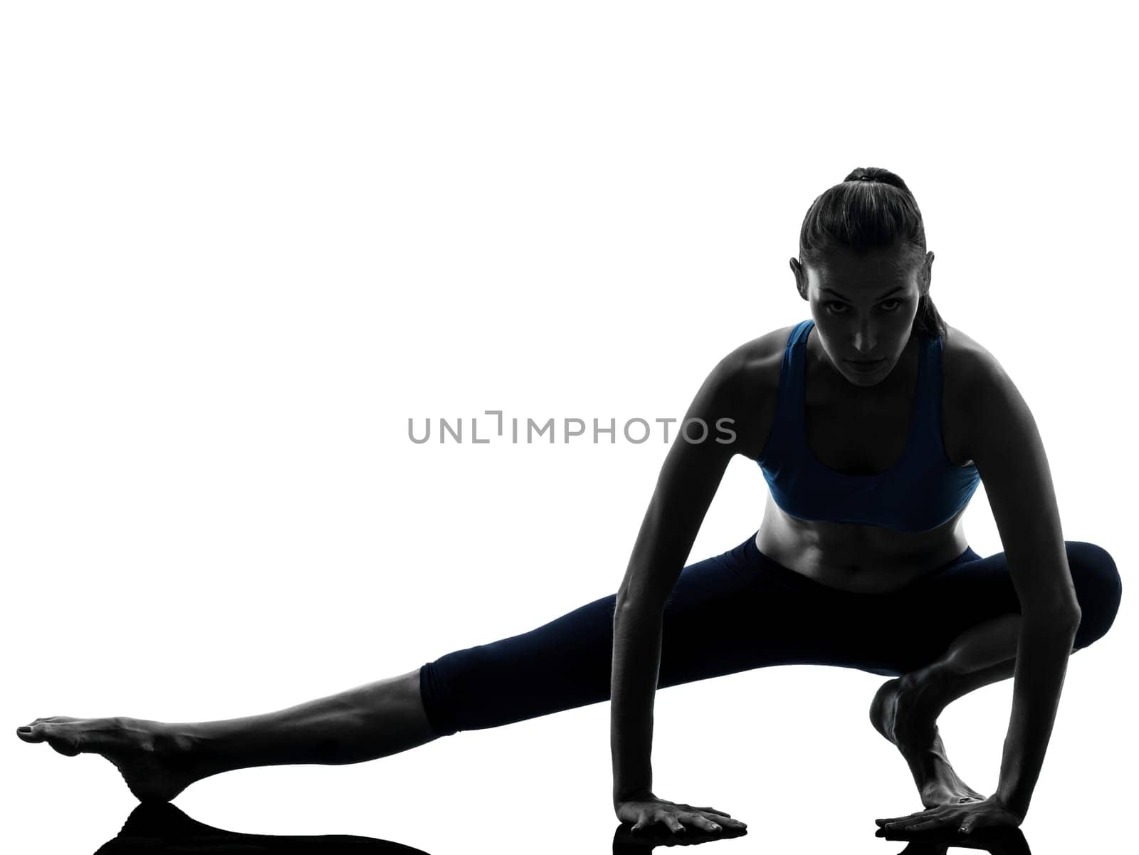 one caucasian woman exercising yoga stretching legs warm up in silhouette studio isolated on white background