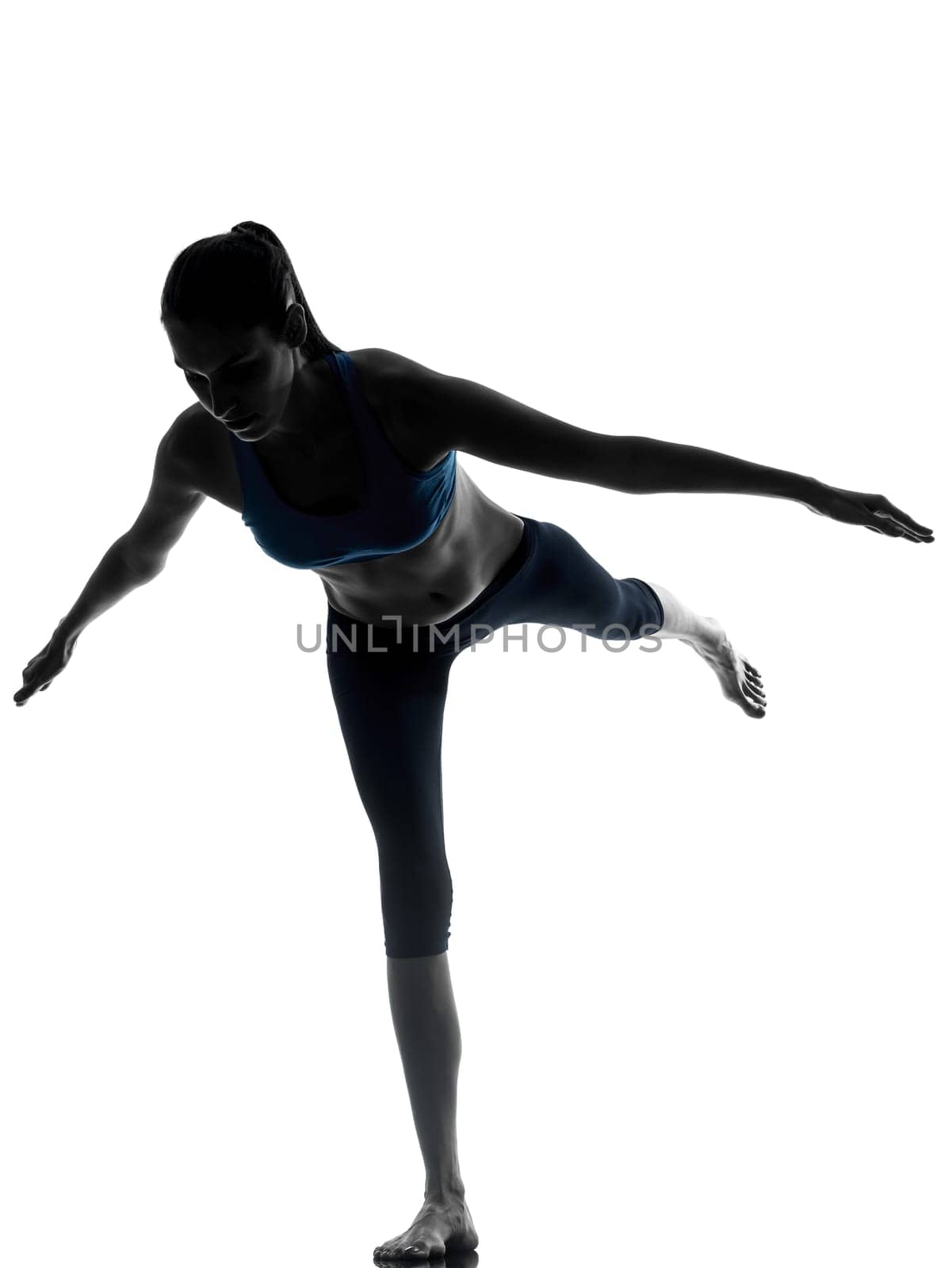 one caucasian woman exercising yoga standing on one leg in silhouette studio isolated on white background