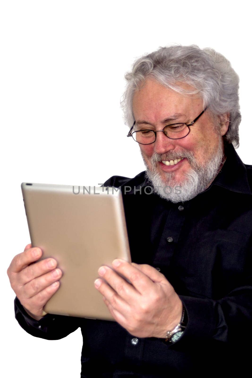 A senior with grey hair is holding a tablet and looking at it laughing
