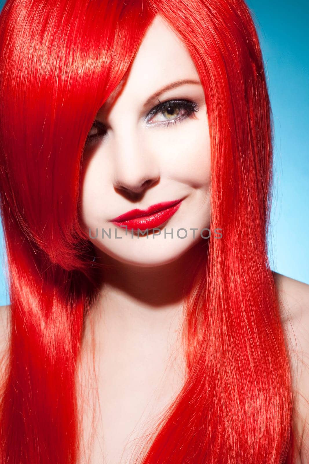 Beautiful young woman with shiny red hair and perfect makeup