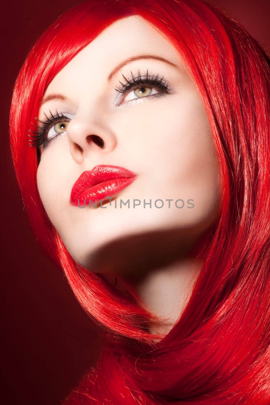Beautiful young woman with shiny red hair and perfect makeup