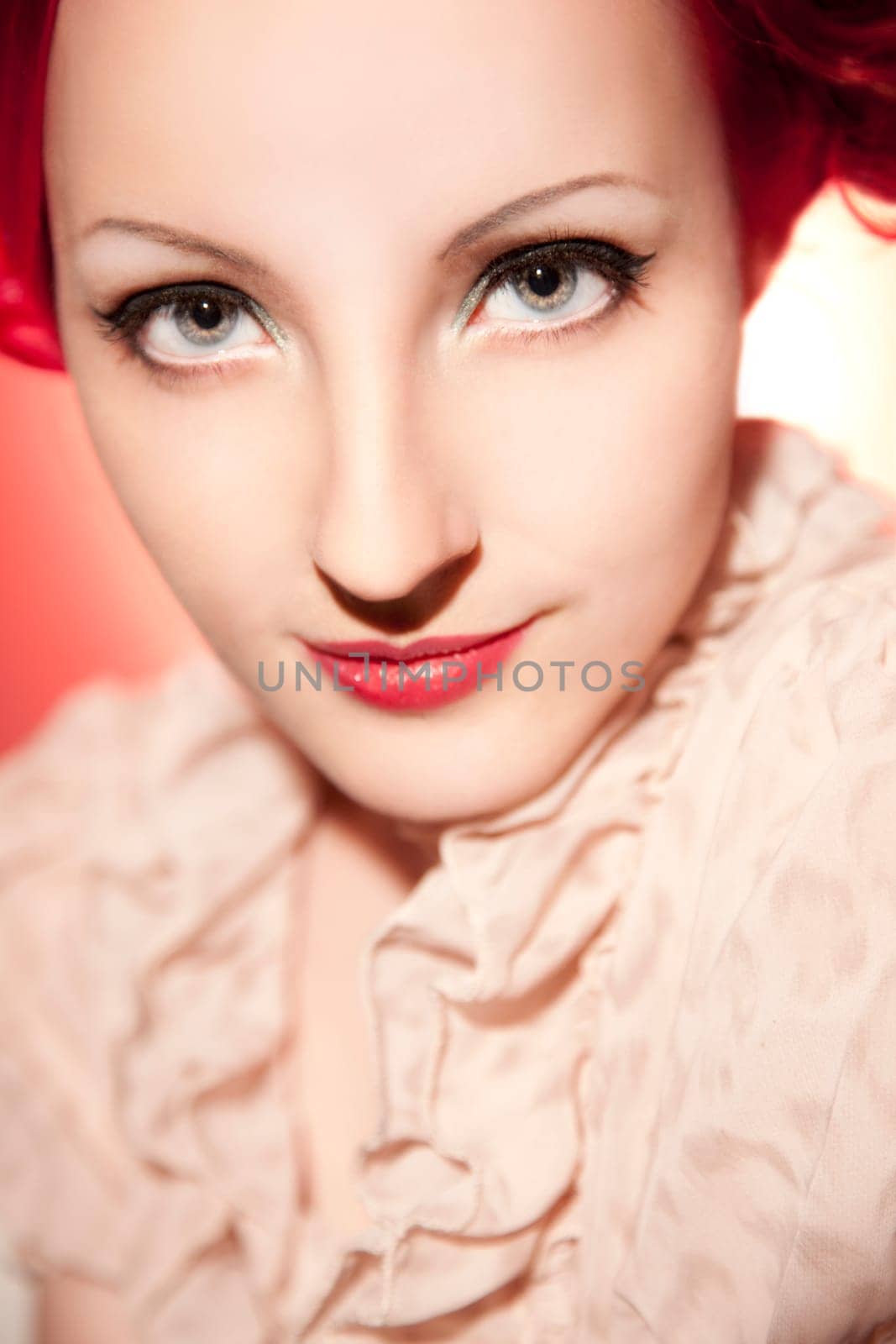 Beautiful young woman with red curls and perfect makeup