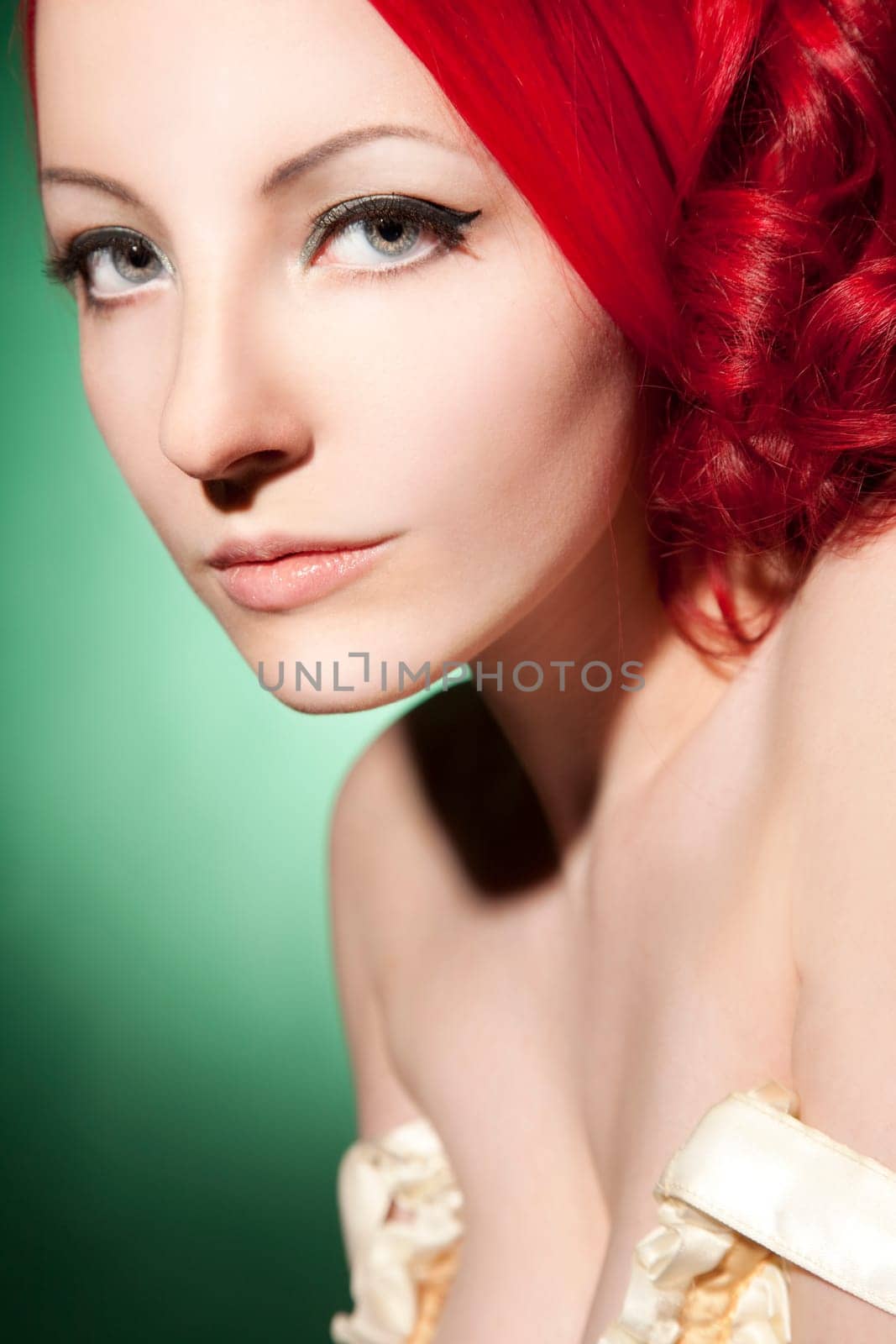 Beautiful young woman with red curls and perfect makeup