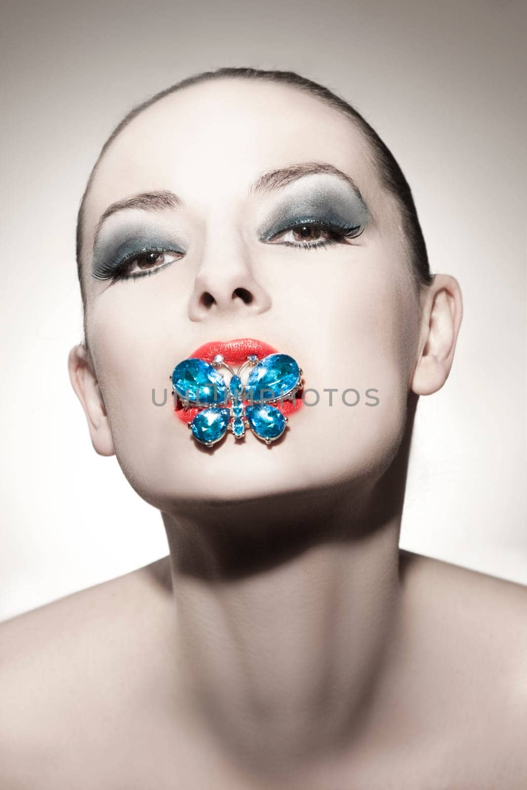 Face of a beautiful young woman with butterfly brooch