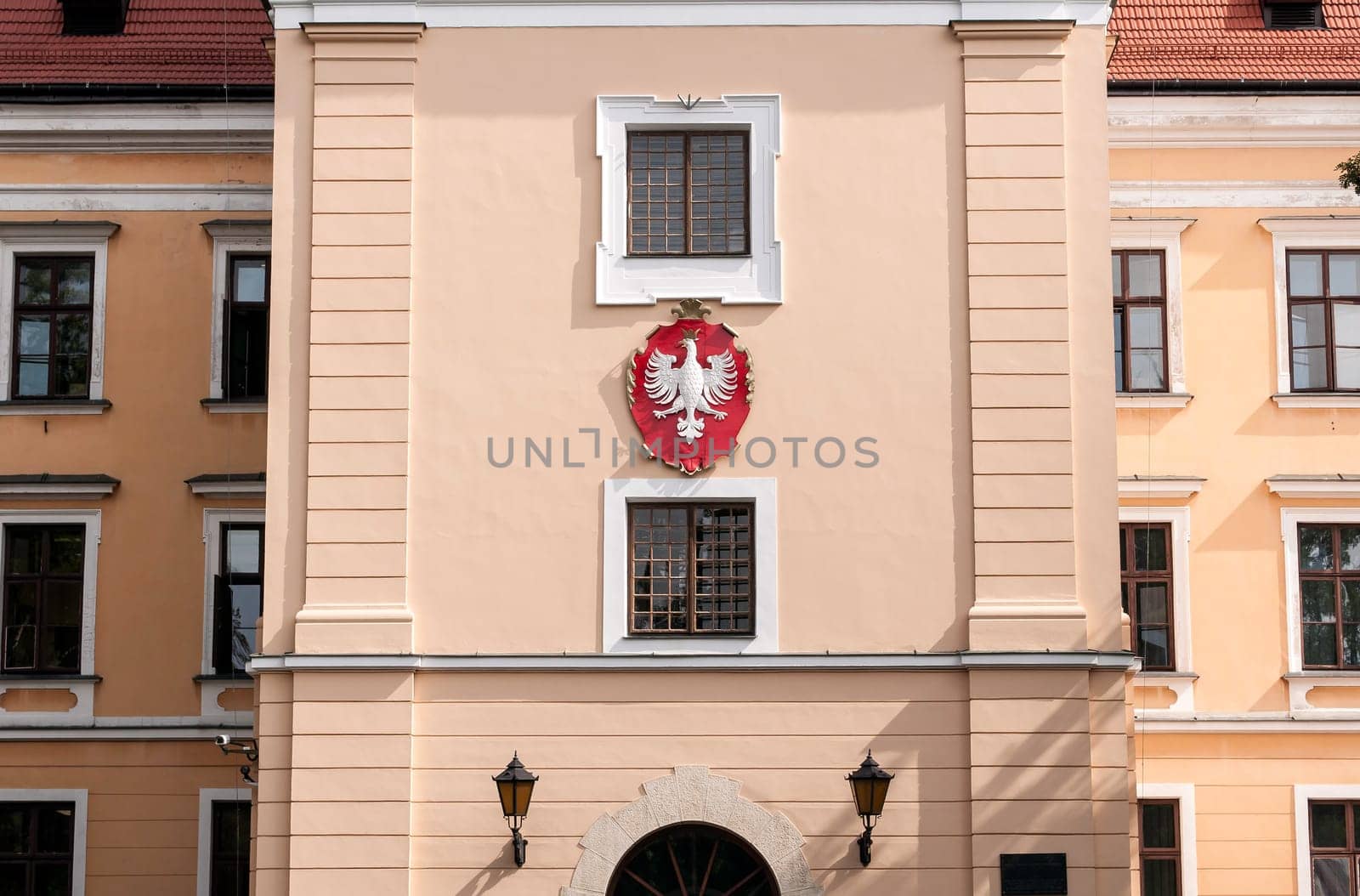 Polish eagle on coat of arms. Front of a traditional polish building.