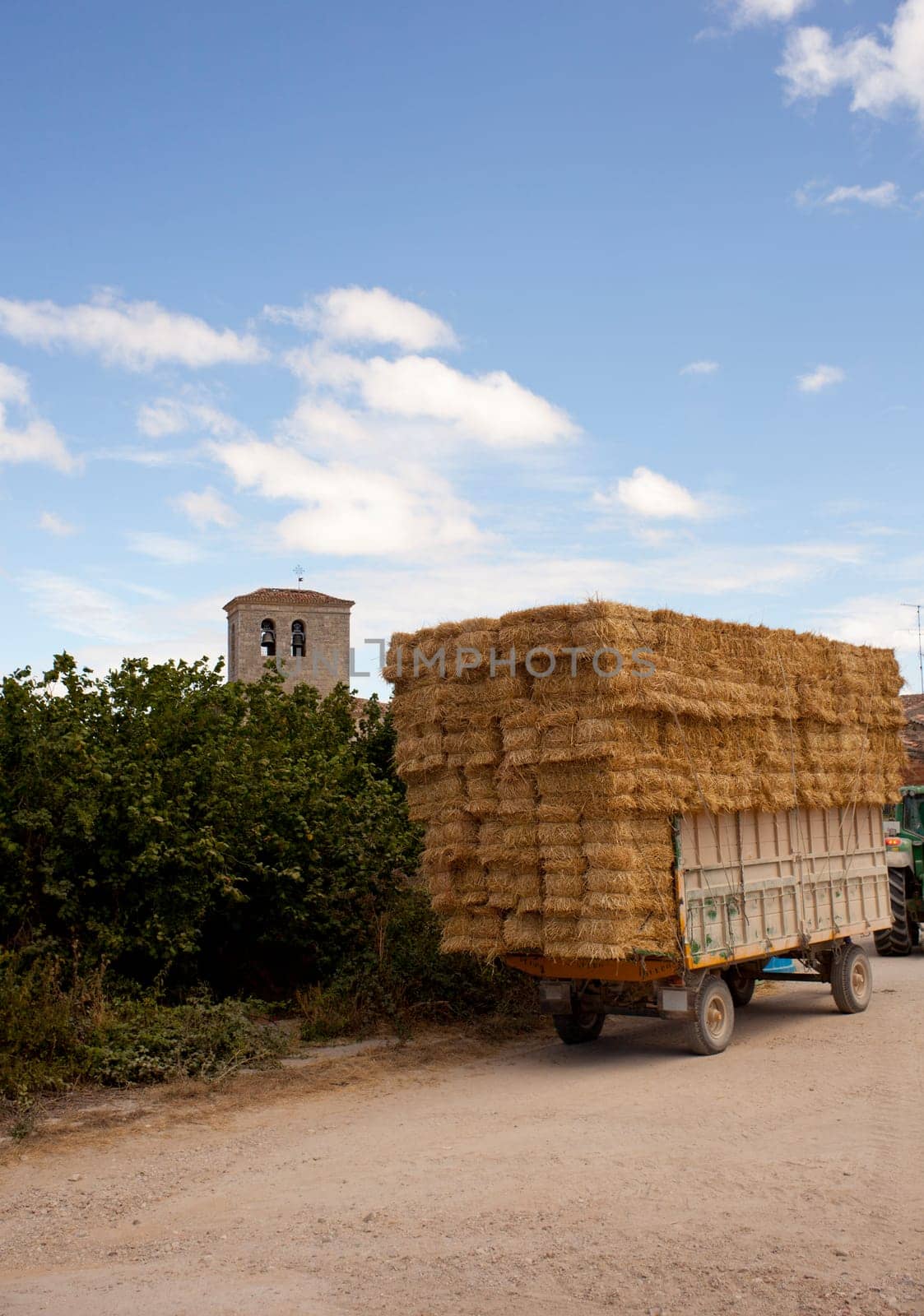 A lot of Bales of hay on the tractor