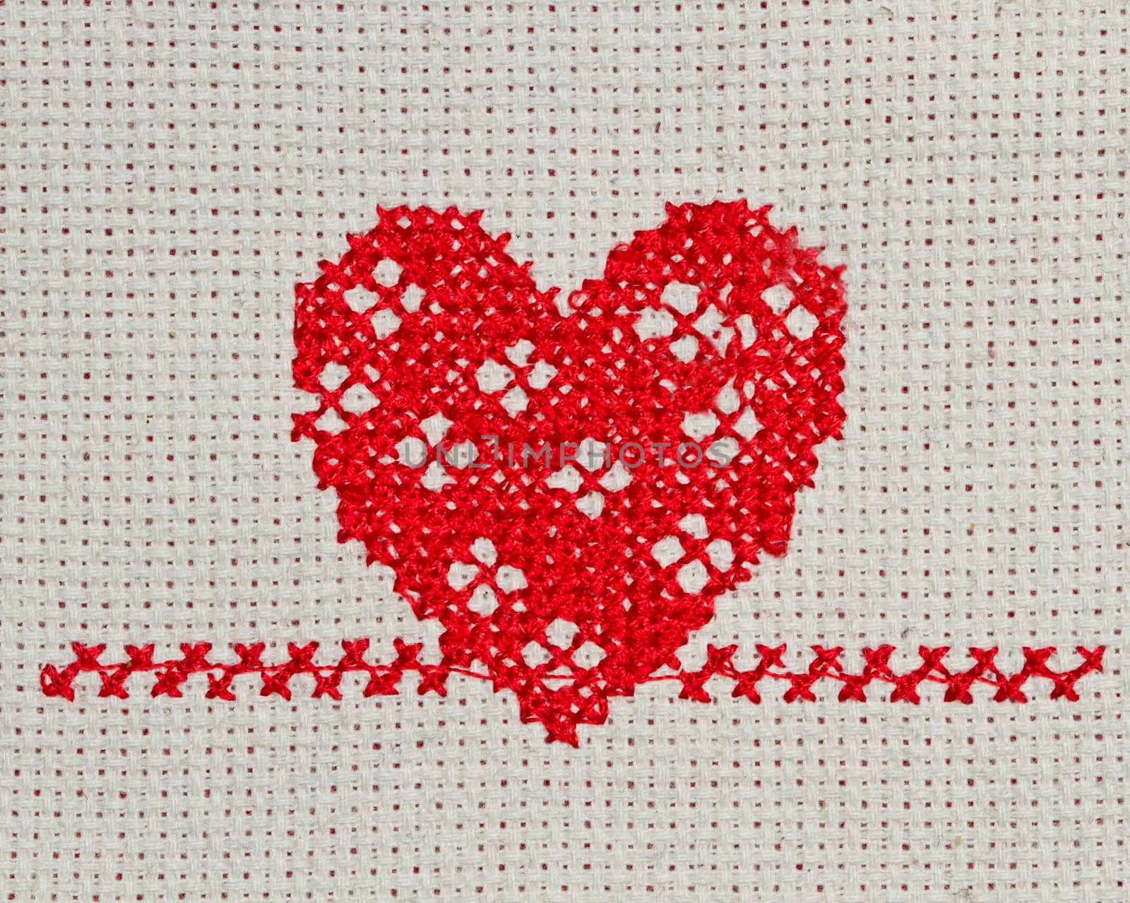 red heart embroidered in cross stitch on  canvas