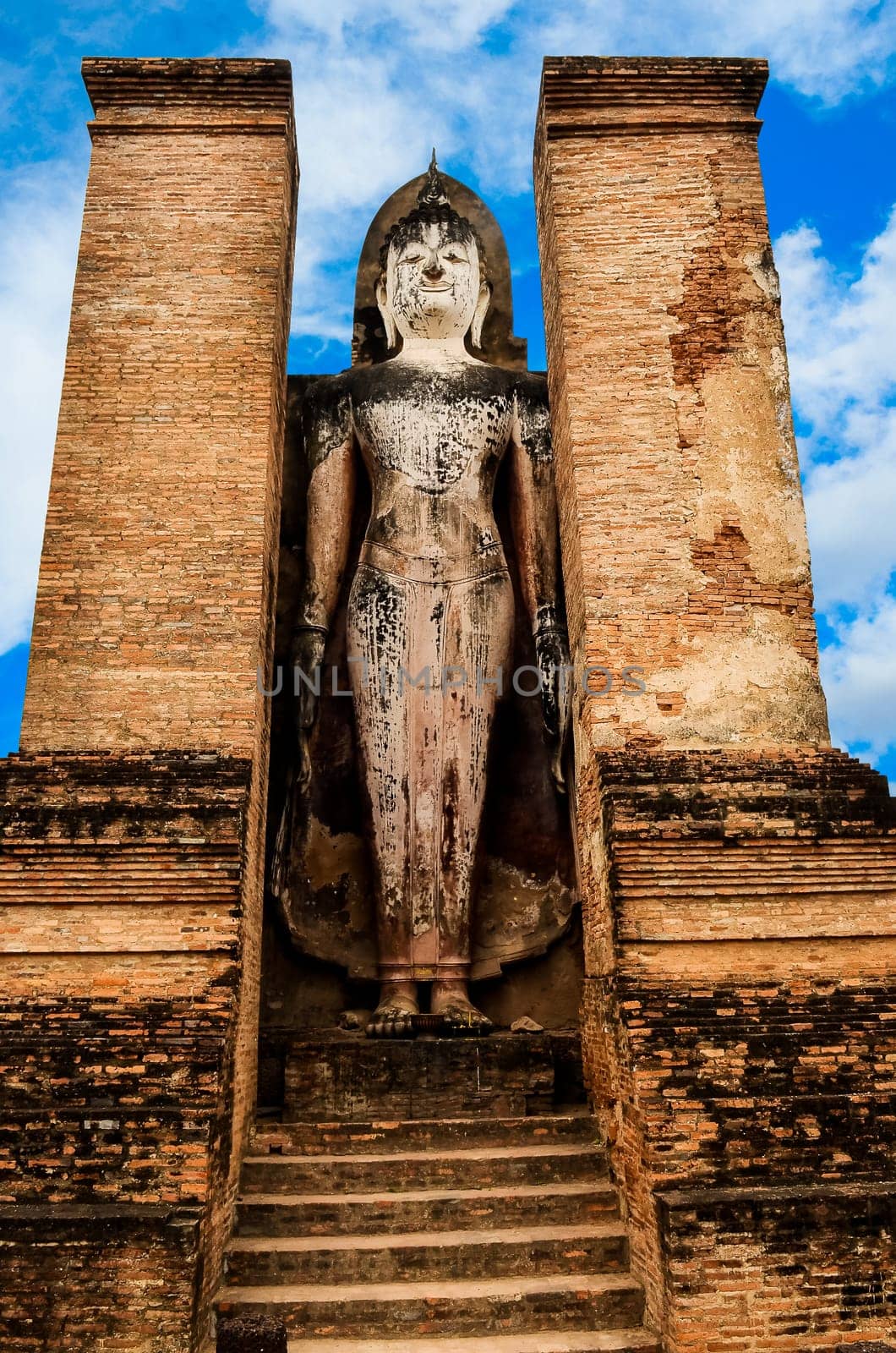 Large statue of standing Buddha in Sukhothai historical park, Thailand