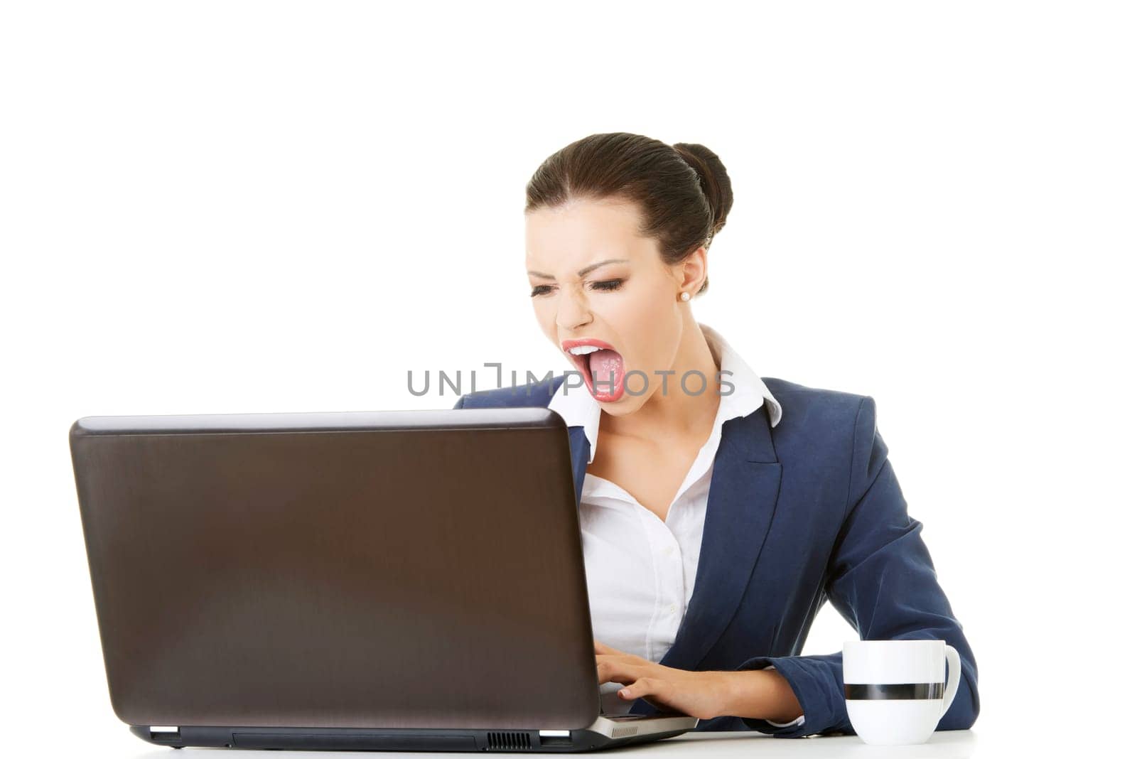 Angry businesswoman shouting on her laptop, isolated on white