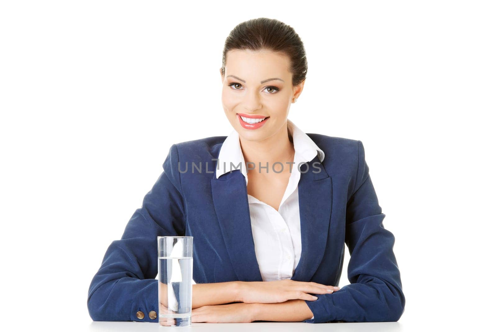 Attractive businesswoman sitting at the desk, isolated on white