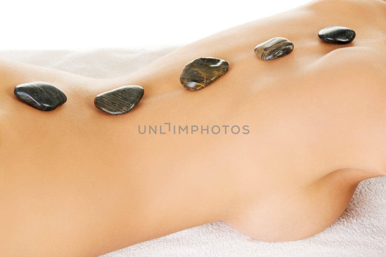 Beauty woman relaxing in spa. Hot stone massage.