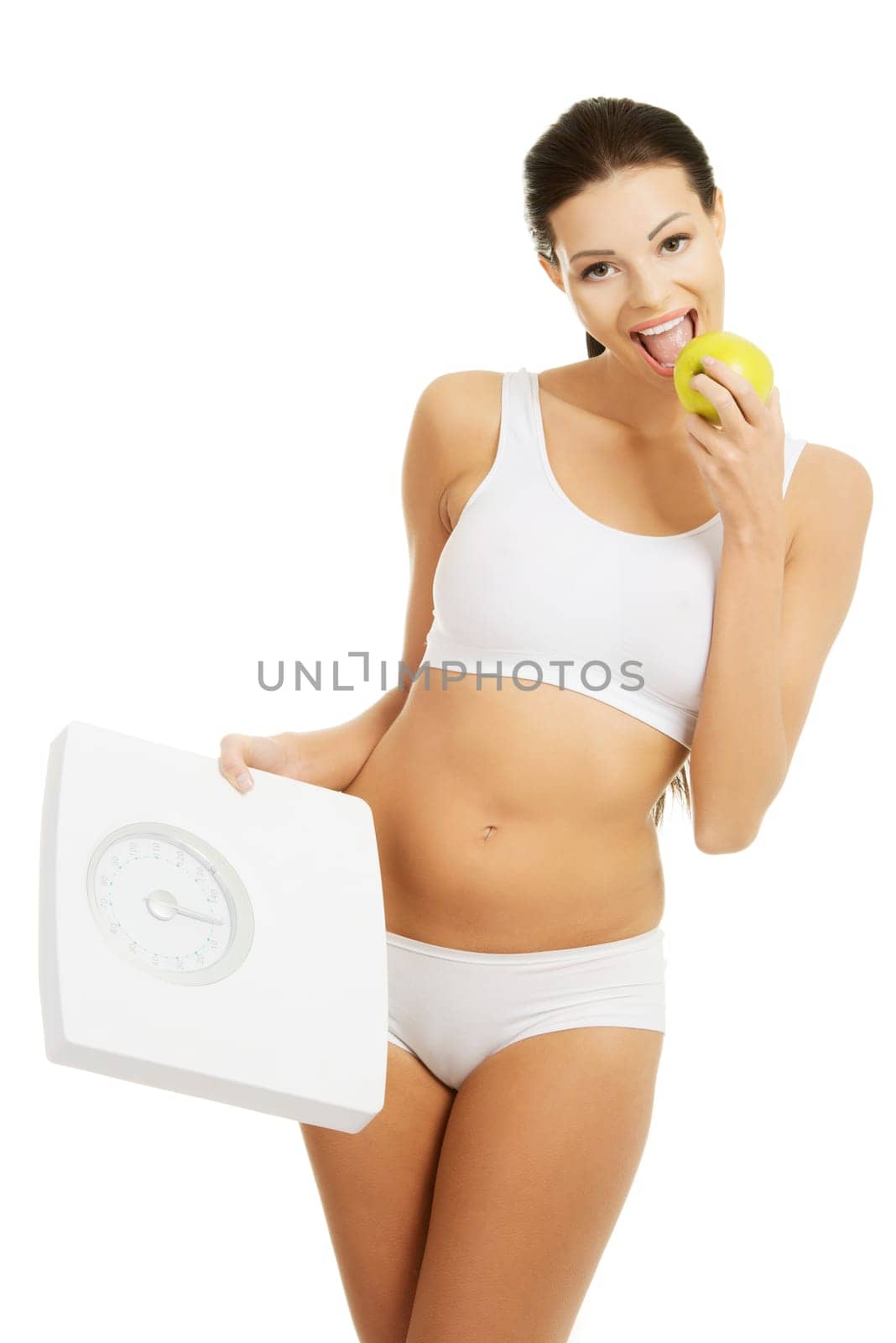Attractive fit woman with scale and apple, isolated on white