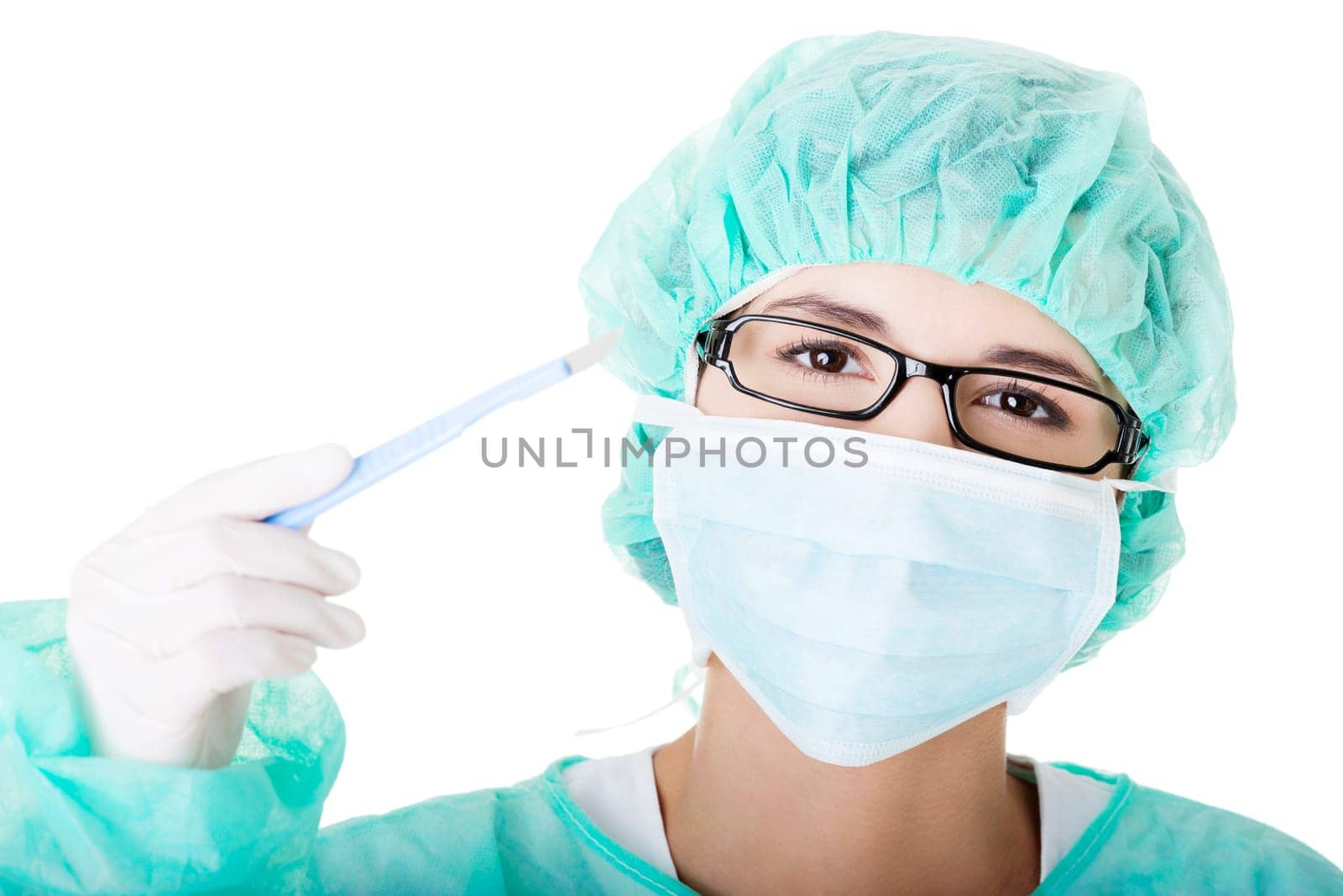 Portrait of woman doctor or nurse with surgical mask and cap holding scalpel
