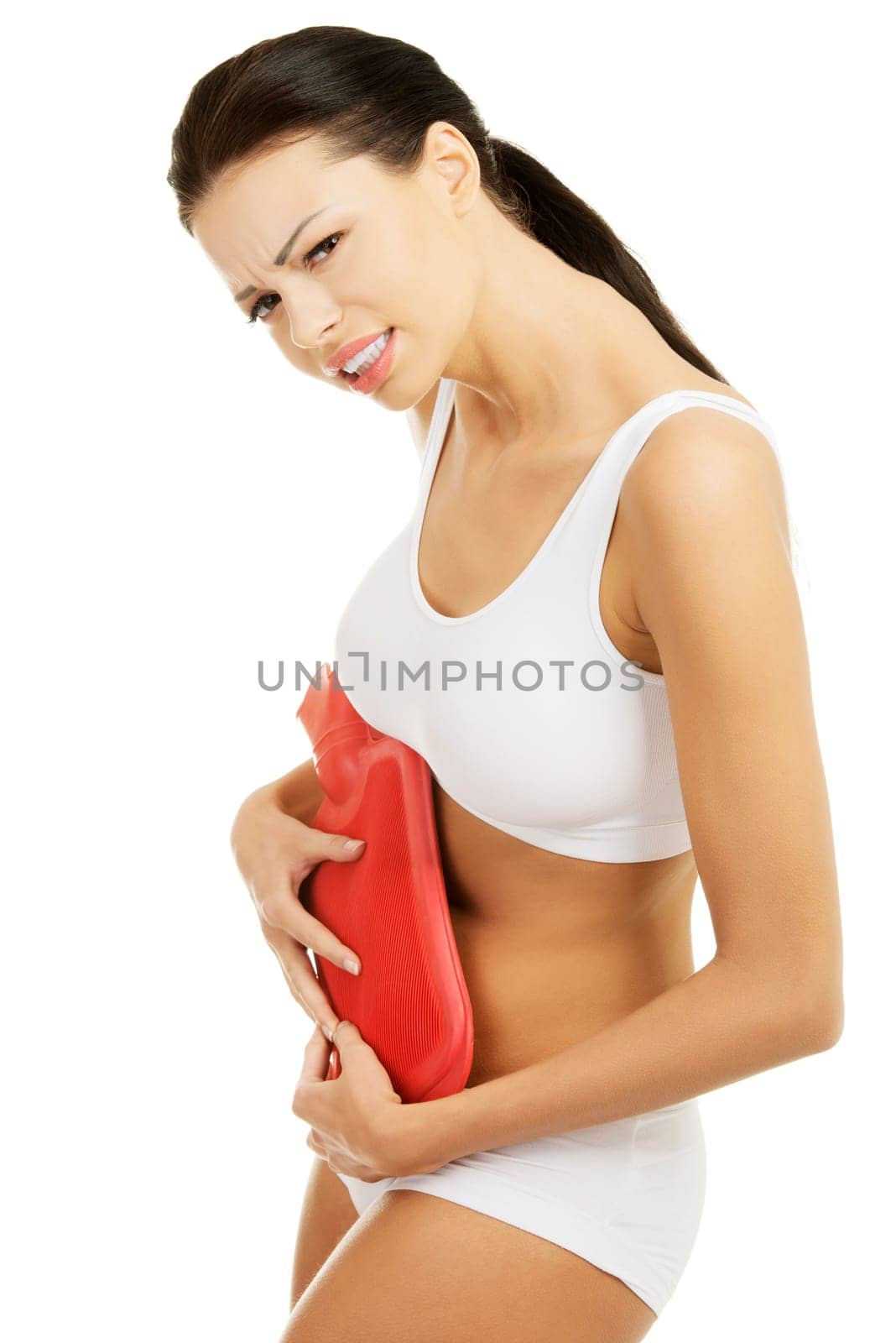 Woman with belly pain holding hot water bottle