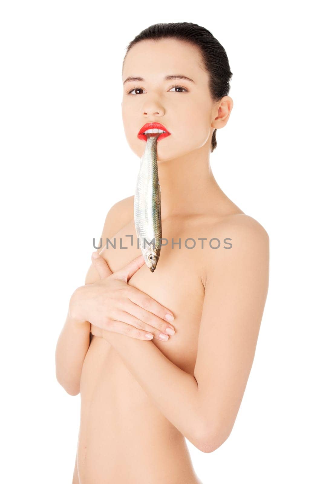 Beautiful young naked woman with fish in her mouth
