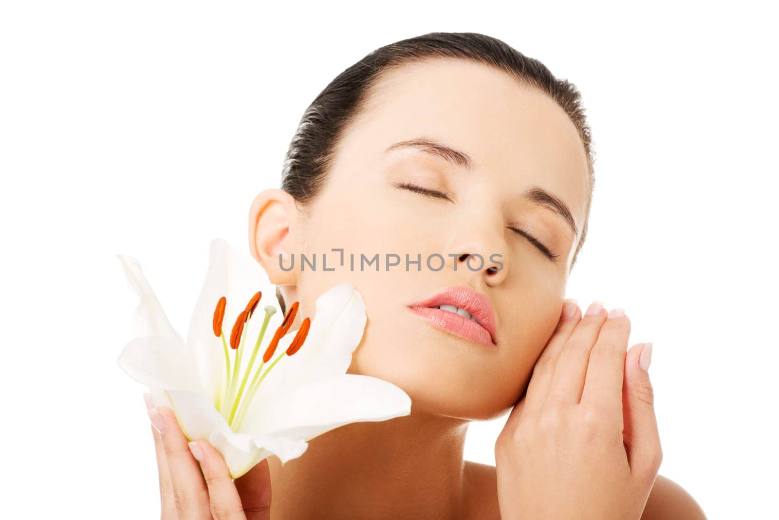 Portrait of beautiful young woman with health skin and with lily flower