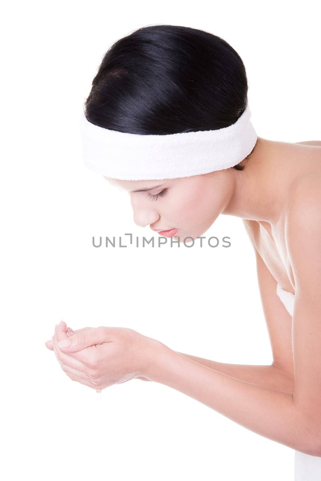 Young female washing her face with clear water