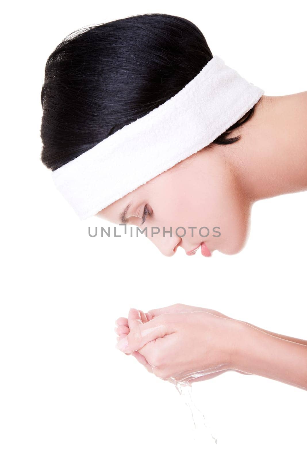 Young female washing her face with clear water