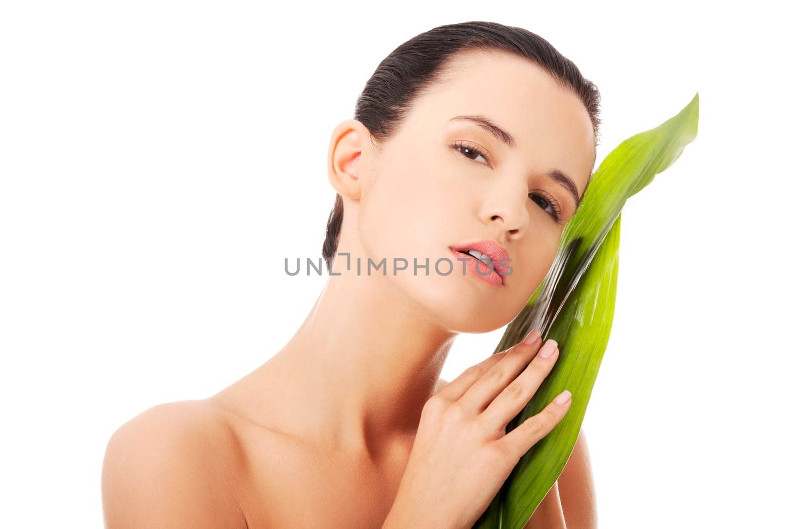 Portrait of young beautiful woman with green exotic leaf