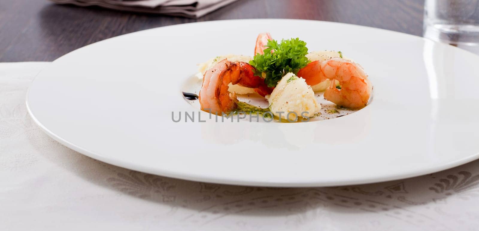 fresh fried prawns with mashed potatoes and green herb sauce on white plate