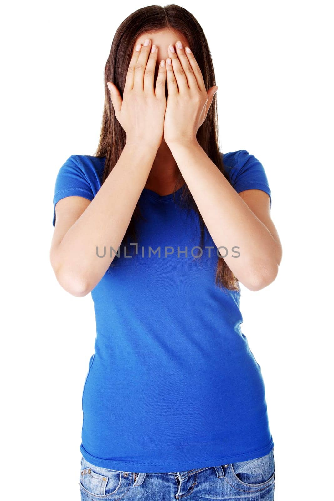 Young teen woman covering her face with hands, isolated on white