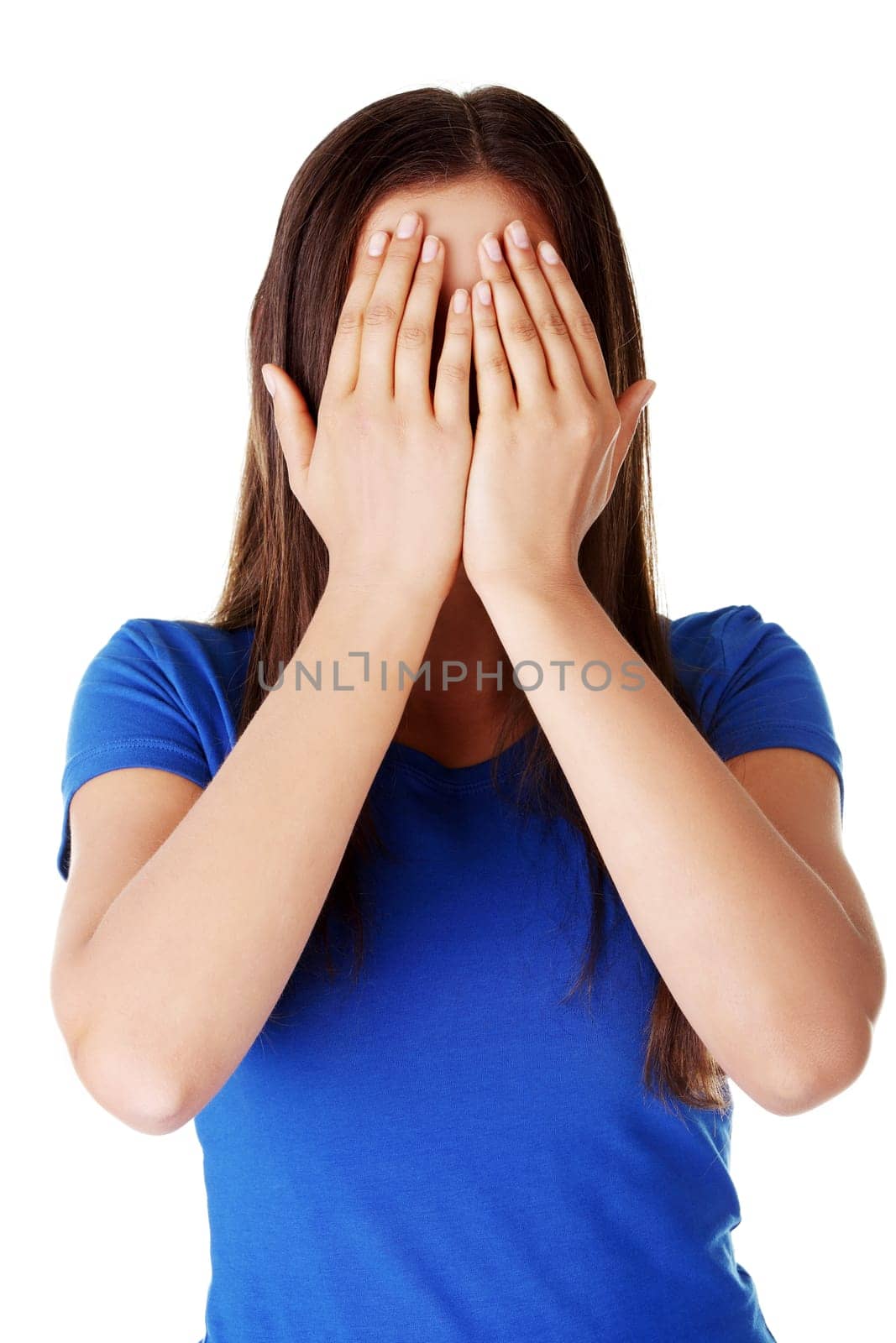 Young teen woman covering her face with hands, isolated on white