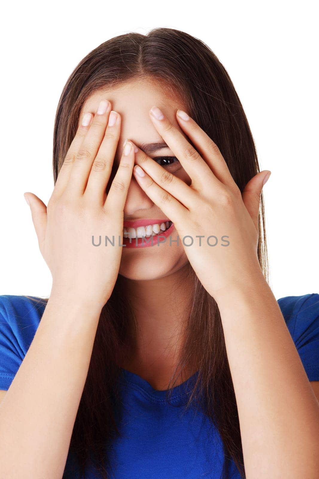 Shy teenage girl peeking through covered face , isolated on white.
