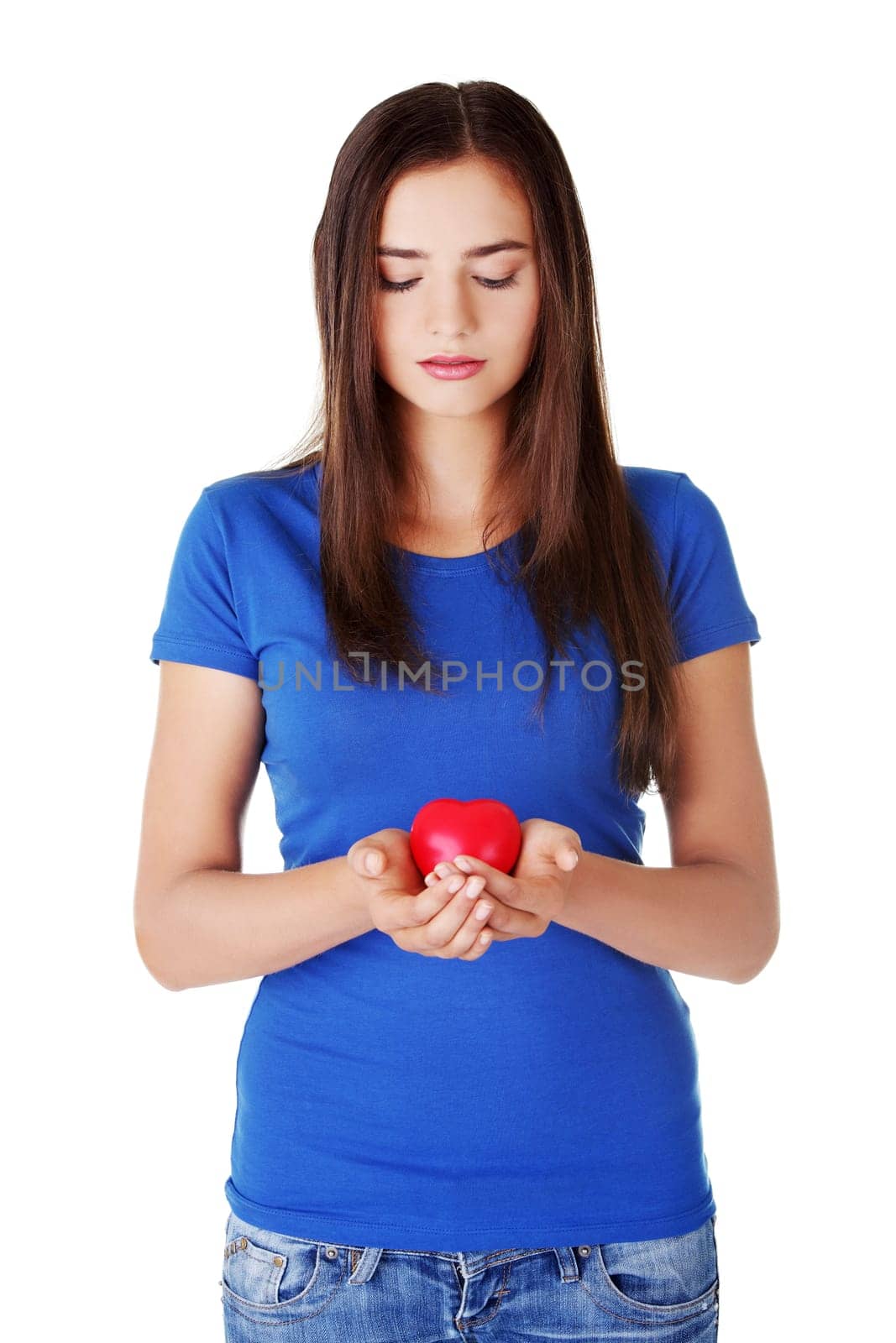 Teen girl holding red heart. Isolated.